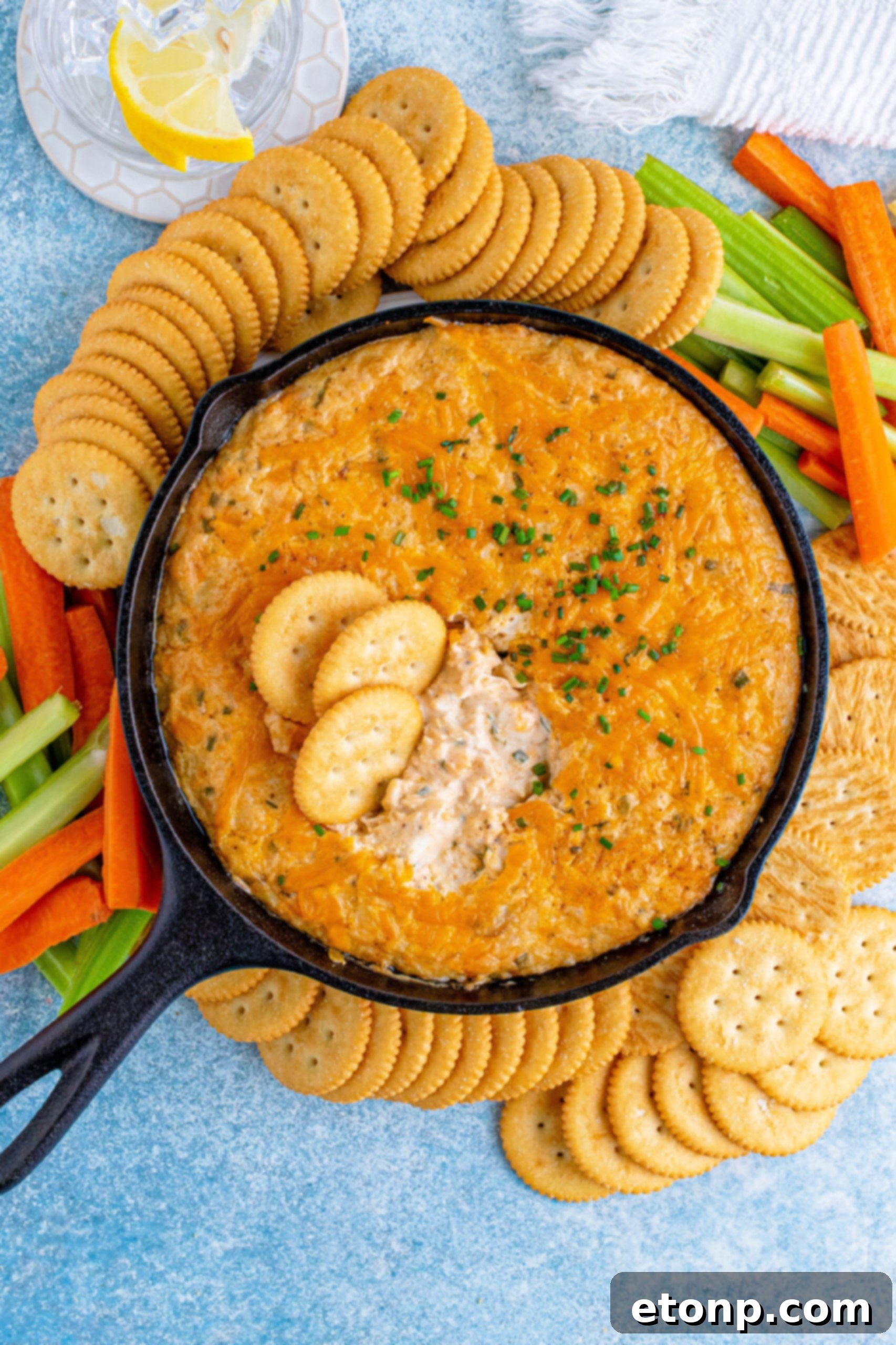 Decadent Crab Delight 14 Overhead view of Crab Dip Recipe in a cast iron skillet served with crackers and vegetables.