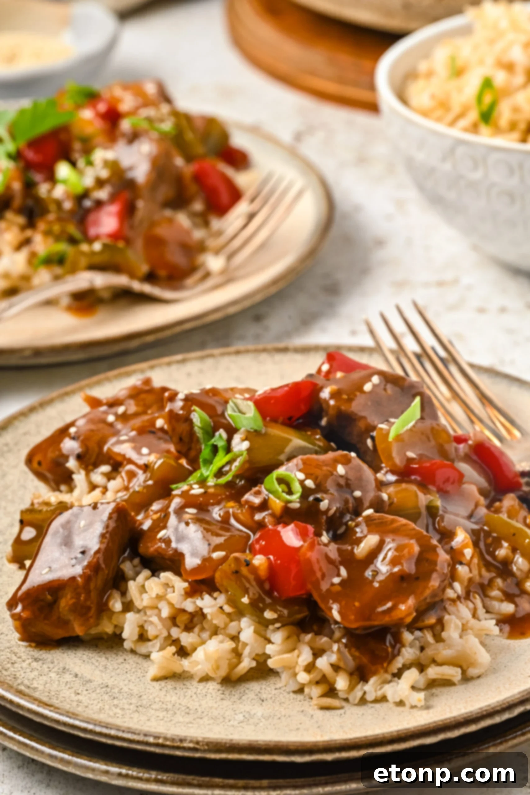 Front view of Chinese Pepper Steak on a dish served over rice.