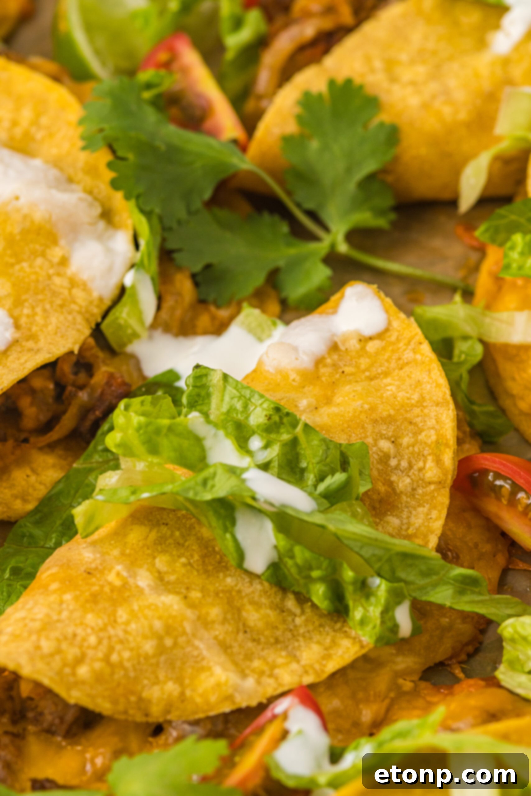 Close-up view of a perfectly crispy baked beef taco, highlighting its golden shell and savory filling.