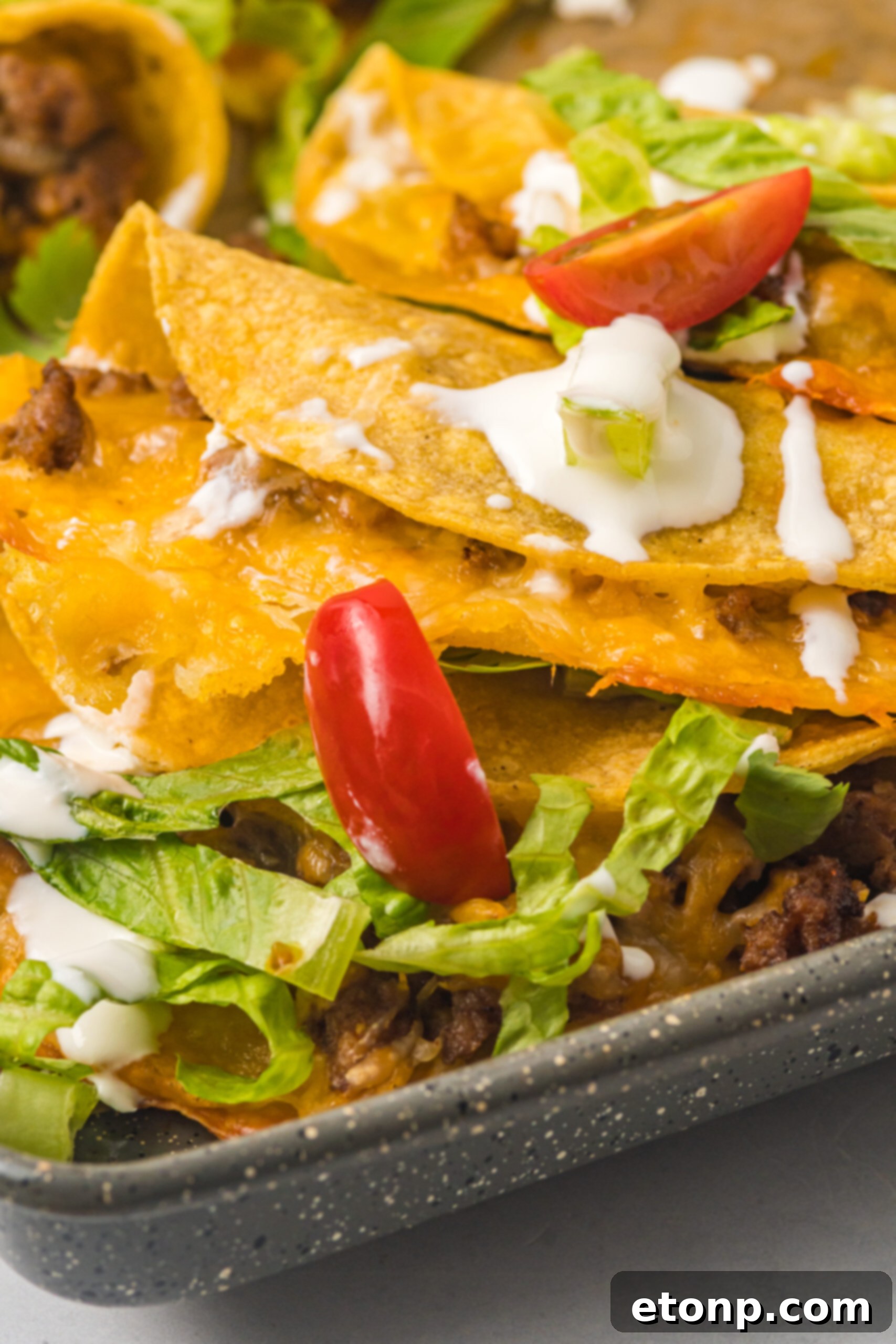 Close-up view of two Crispy Baked Beef Tacos on a sheet pan, showcasing their textured shells and a hint of the savory filling.