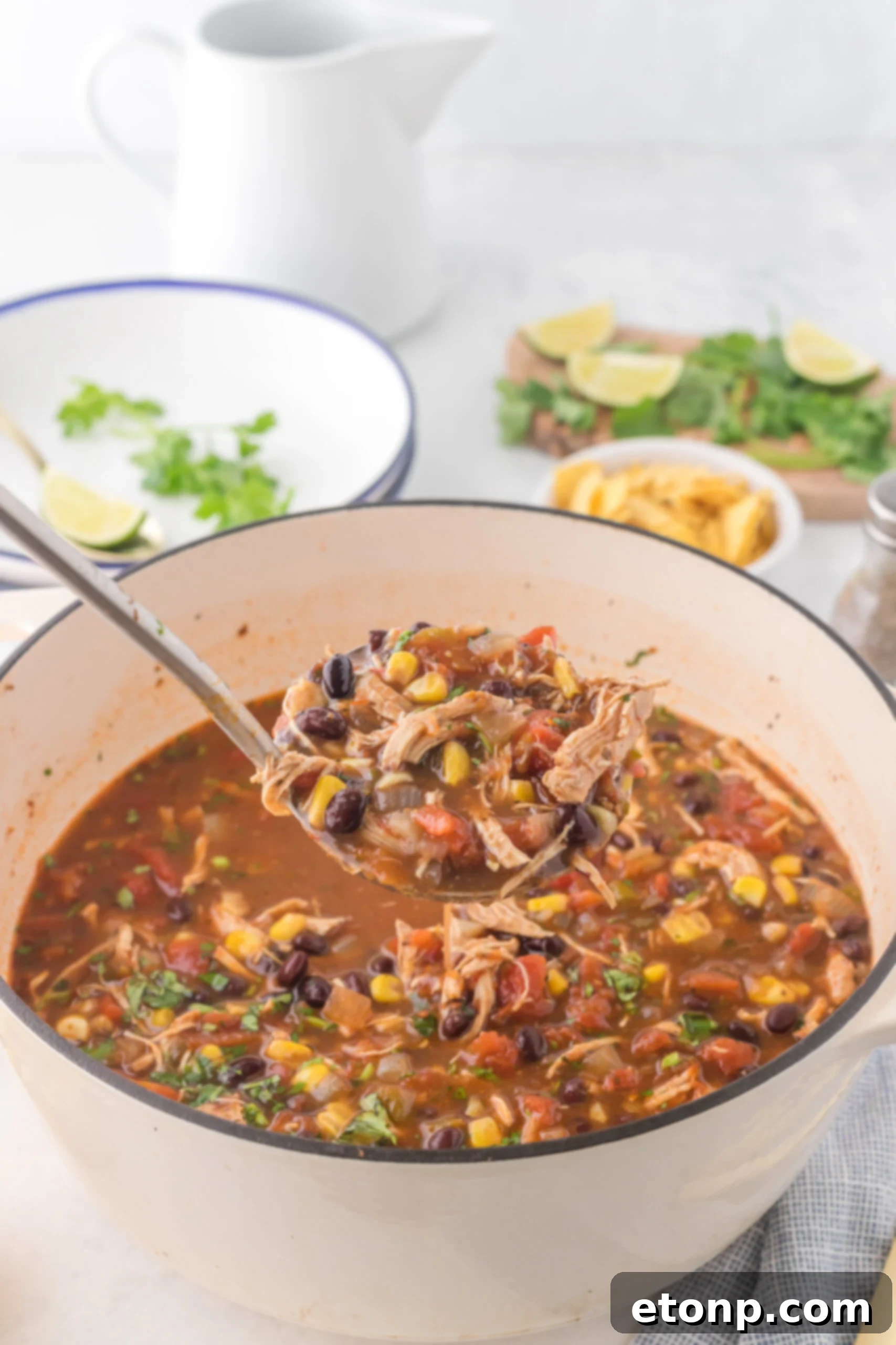 Chicken Taco Soup being served in a silver ladle, highlighting its rich color and chunky texture.