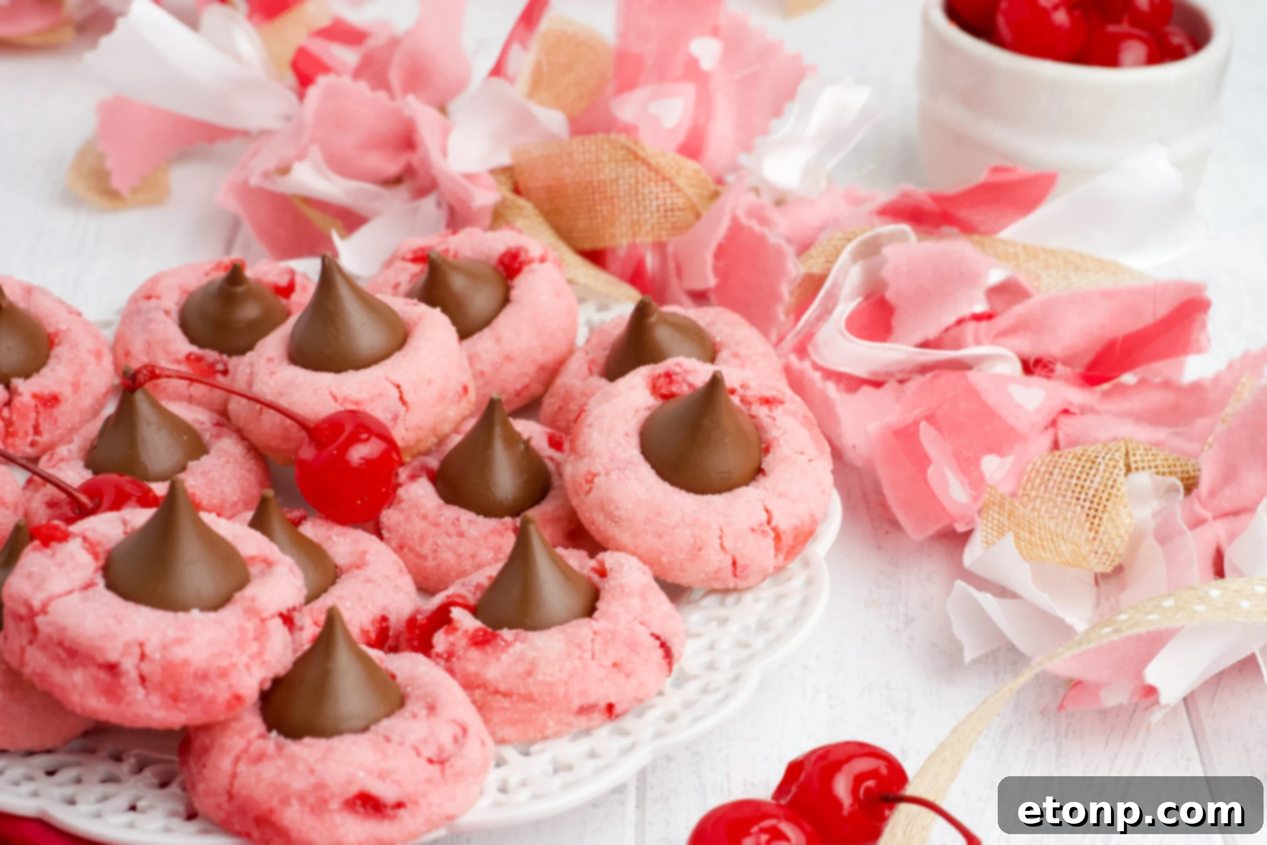 A close-up, front view of Cherry Blossom Cookies on a white dish, emphasizing their texture and the perfectly placed chocolate.