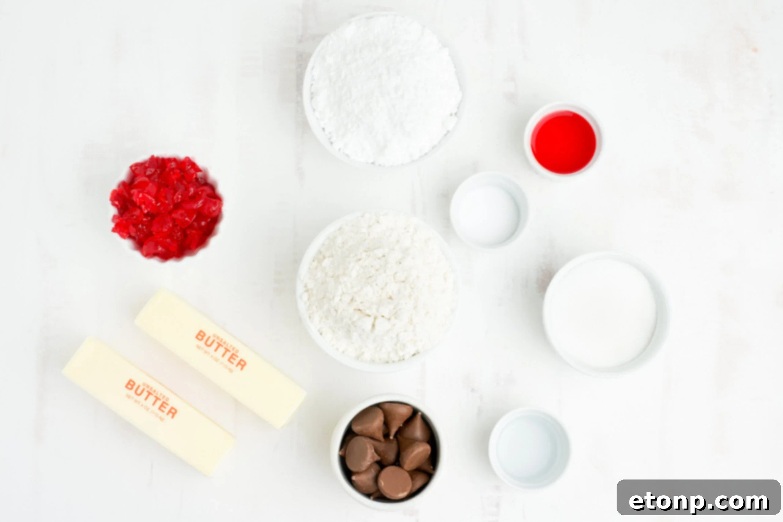 An overhead view of the carefully measured ingredients laid out for the Cherry Blossom Cookie recipe, including butter, sugars, cherries, and extracts.