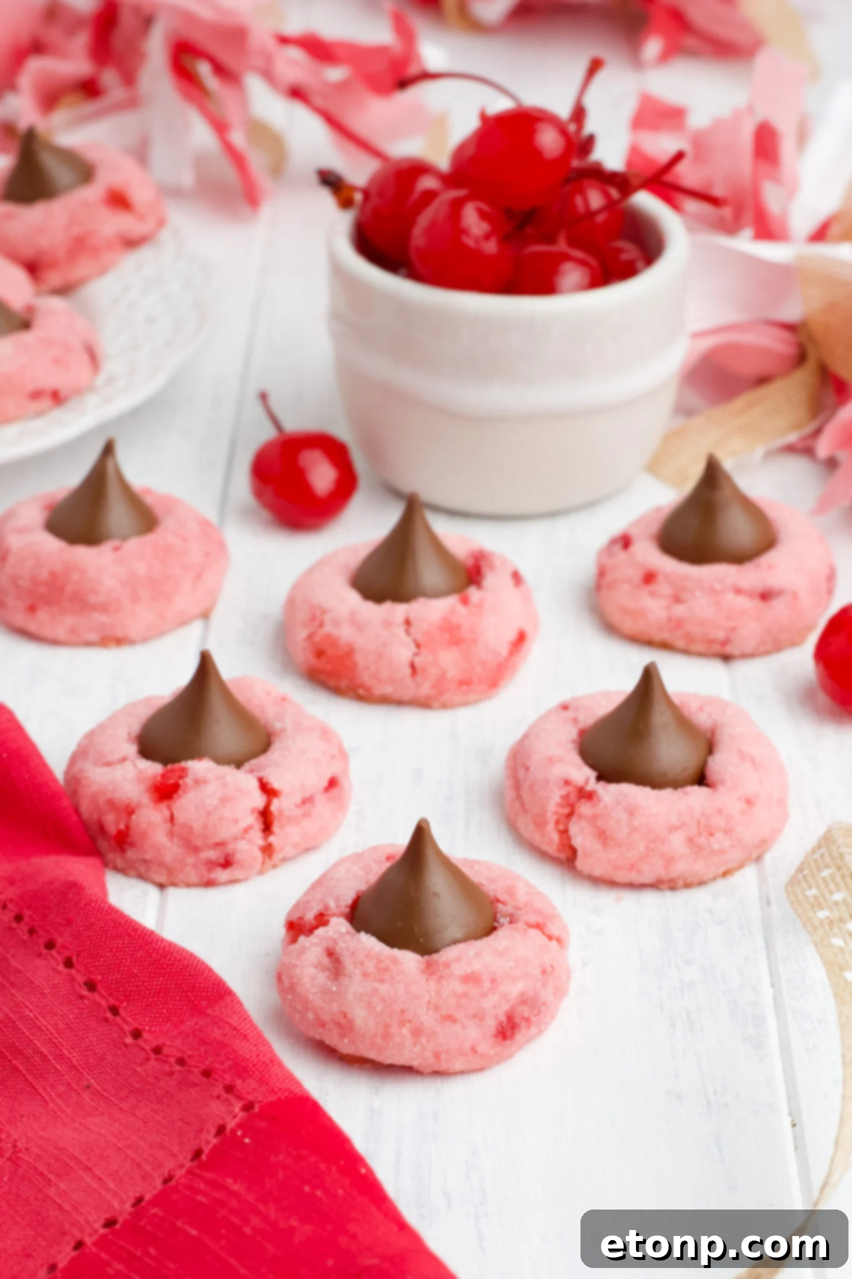A vibrant front view of freshly baked Cherry Blossom Cookies, each topped with a perfectly melted Hershey Kiss, ready to be enjoyed.