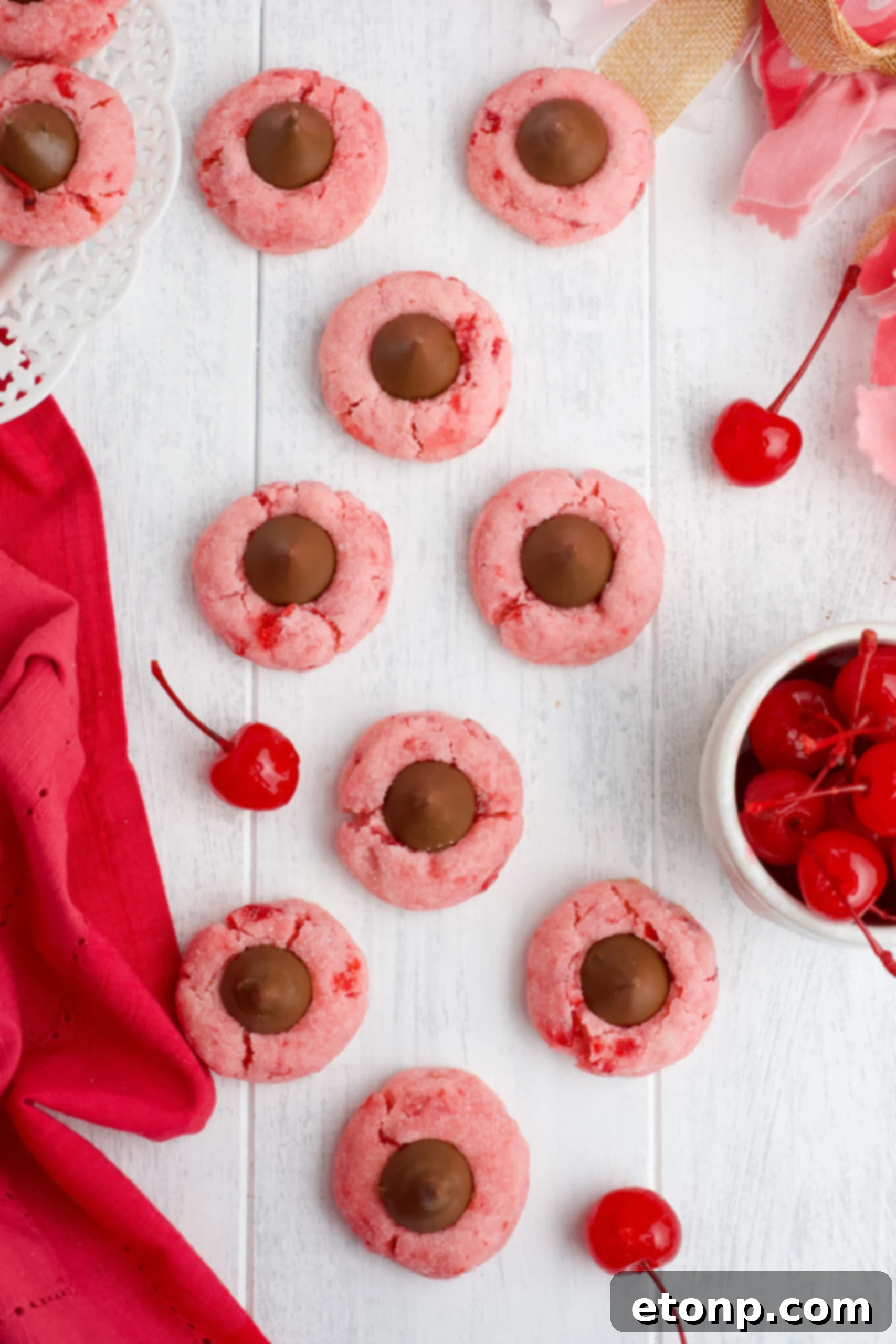 An overhead shot of freshly baked Cherry Blossom Cookies with their shiny chocolate kisses, beautifully displayed.