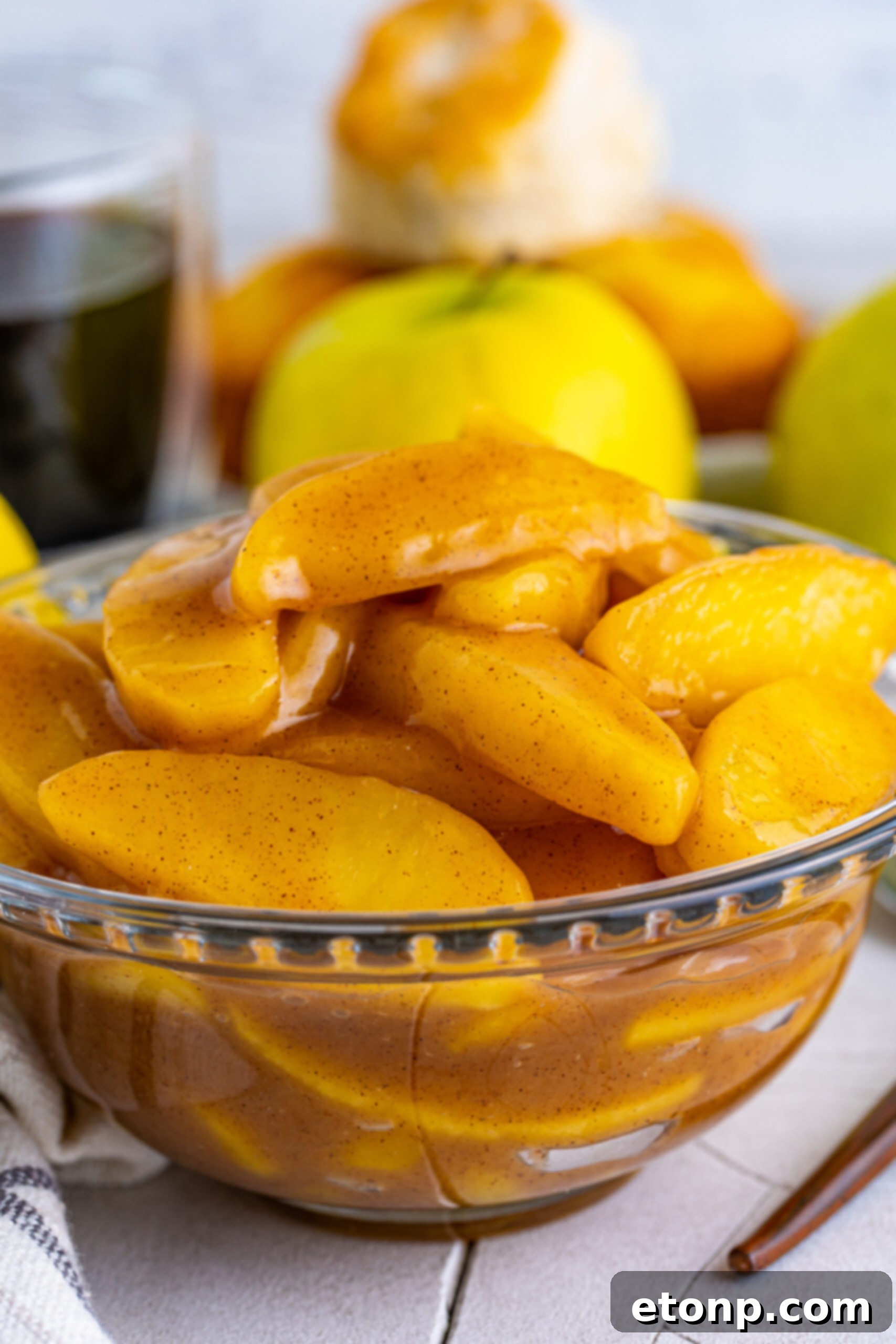 Close up view of perfectly caramelized Cracker Barrel Fried Apples in a clear glass bowl, showcasing their golden-brown hue and tender texture.