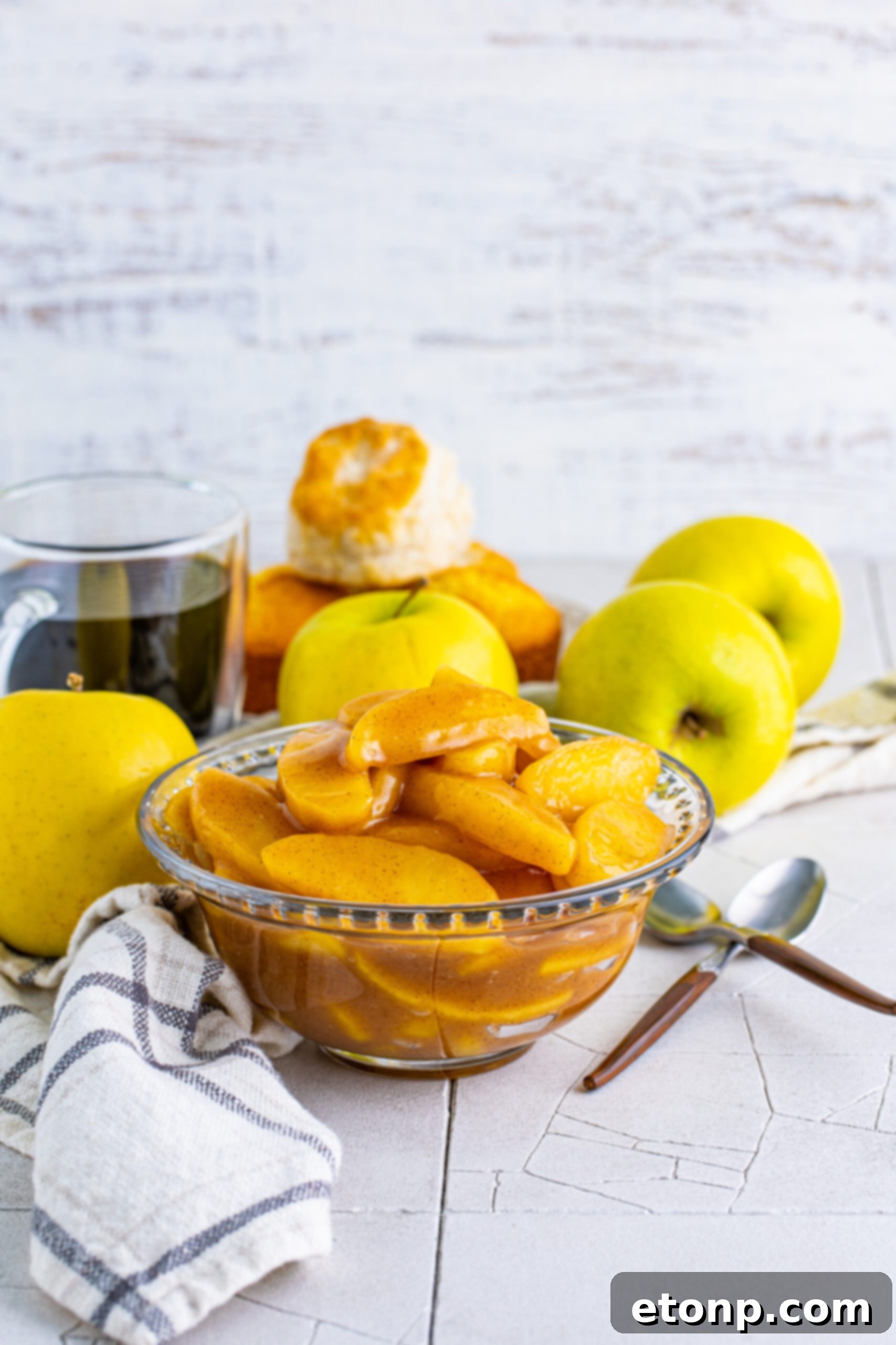 Front view of a clear glass bowl showcasing the rich, golden-brown Cracker Barrel Fried Apples, garnished beautifully.