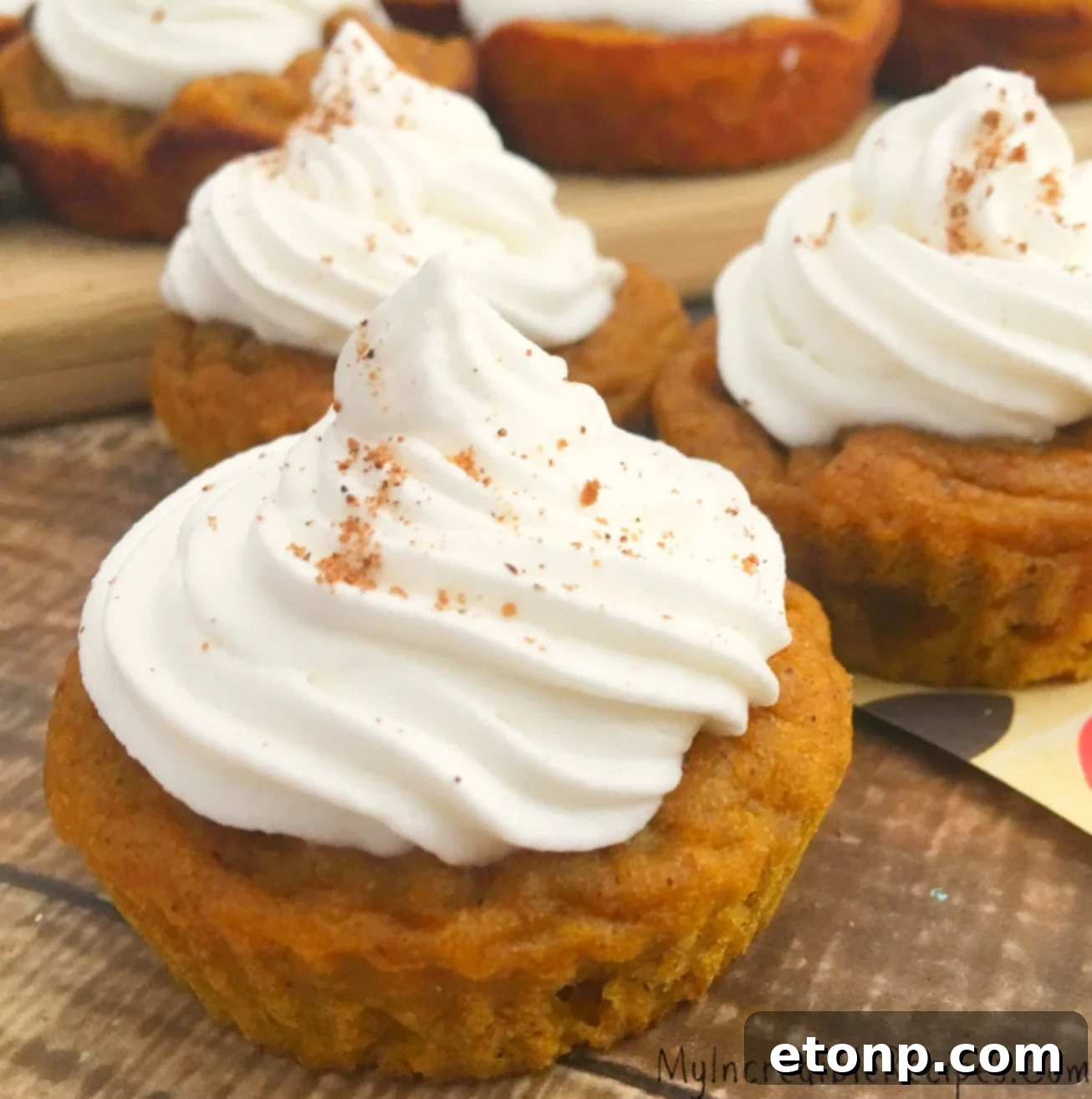 An inviting overhead shot of several pumpkin pie cupcakes, garnished and ready to be enjoyed.