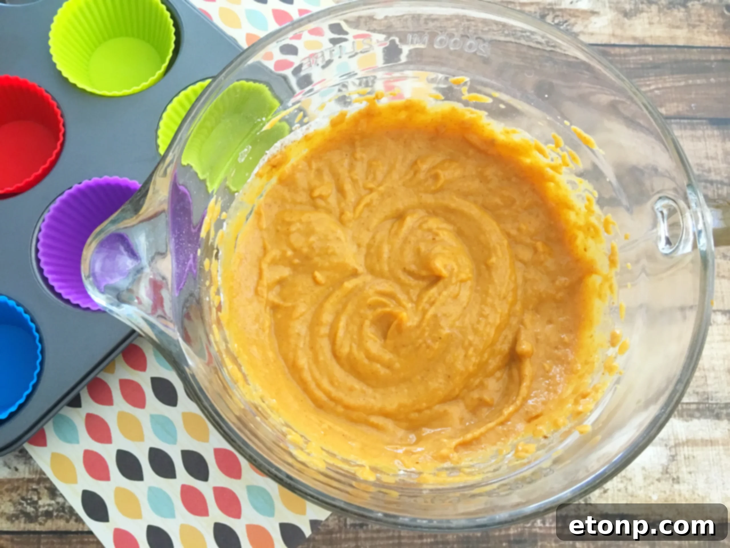The delicate texture of the pumpkin cupcake, showing the rich orange color of the batter.