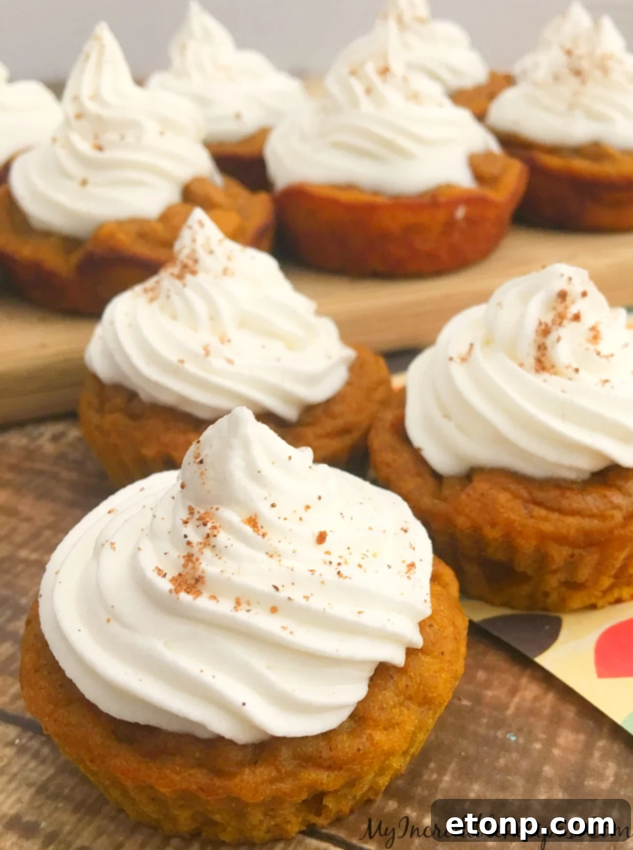 A festive display of pumpkin pie cupcakes on a wooden board, ready to be served.