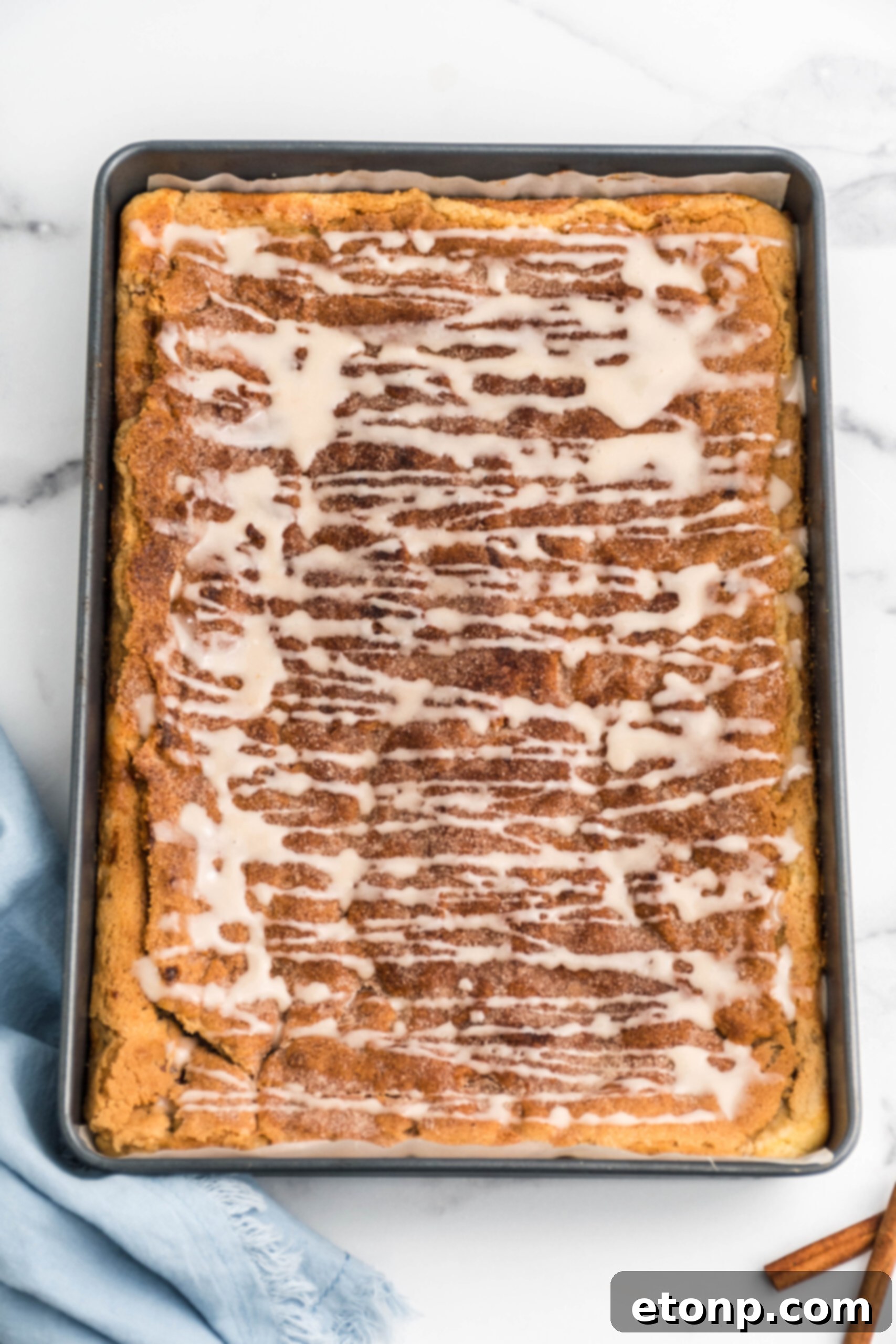 Overhead view of Snickerdoodle Cheesecake Bars in a baking pan.