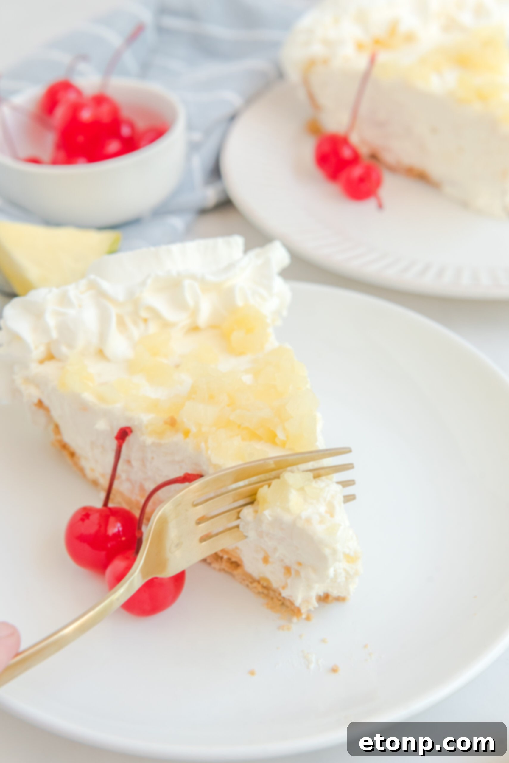 Chilled Pineapple Cheesecake Bliss 19 Up close view of a gold fork removing a bite of No Bake Pineapple Cheesecake.