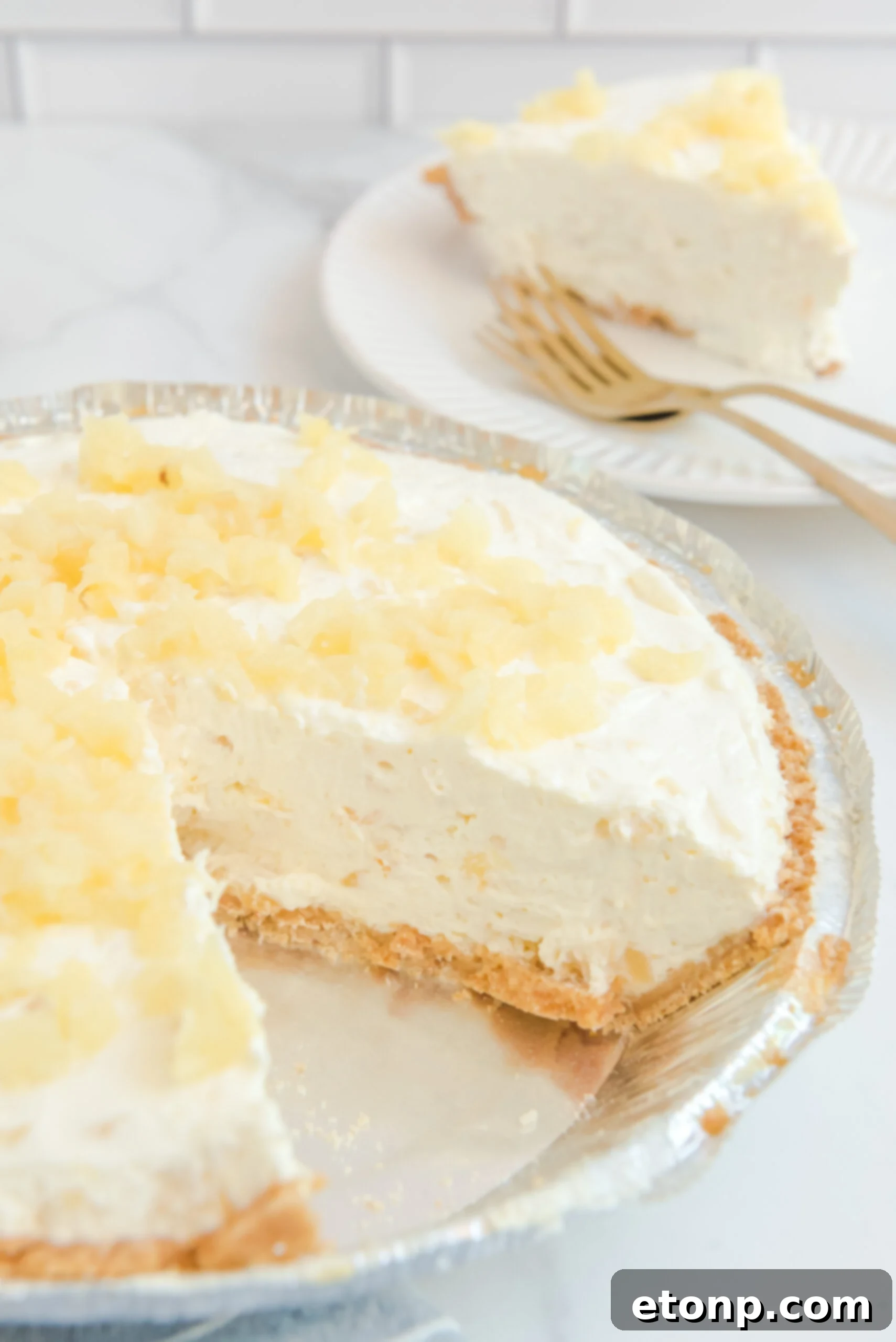 Chilled Pineapple Cheesecake Bliss 4 No Bake Pineapple Cheesecake Pie in a pie plate with a slice removed