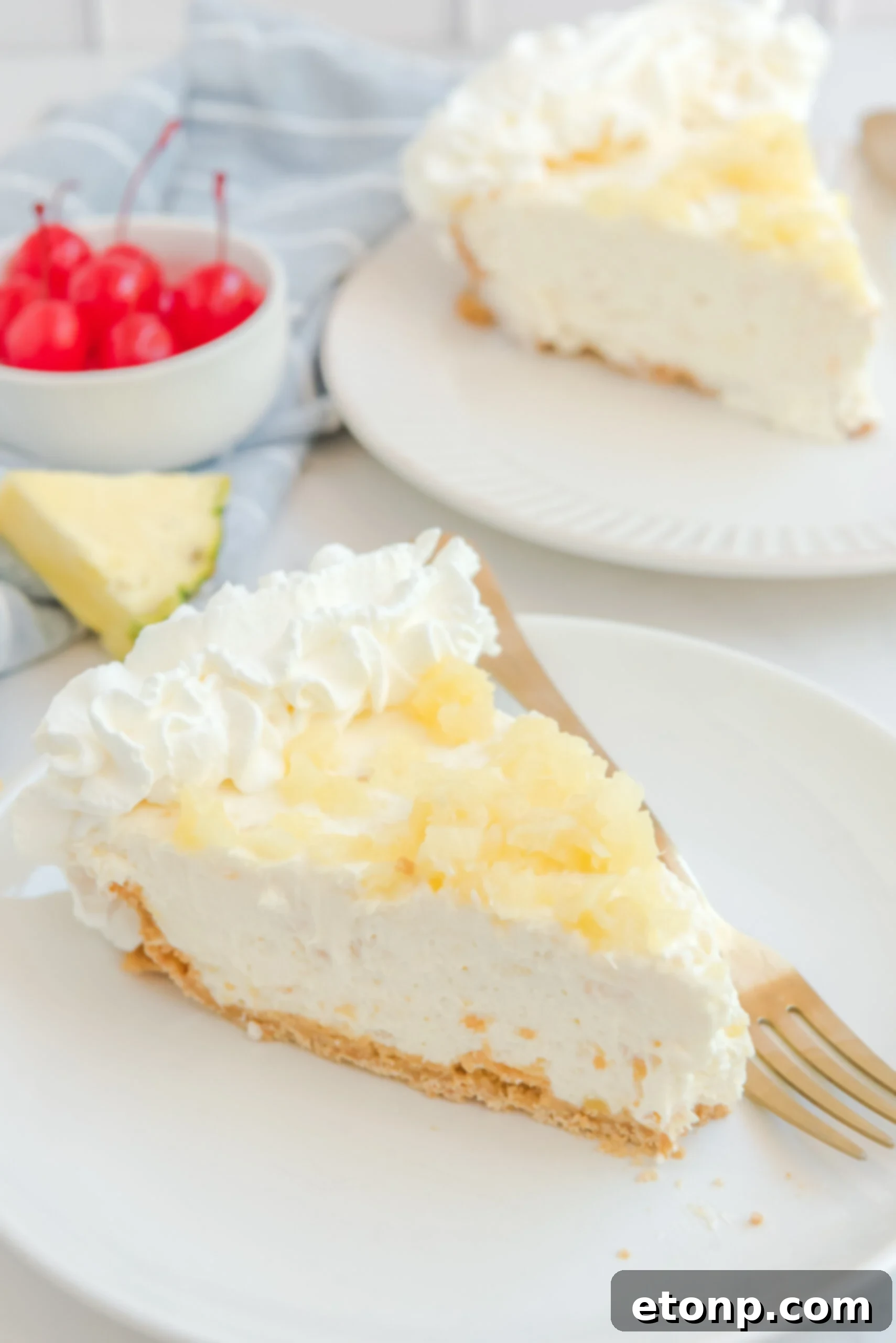 Chilled Pineapple Cheesecake Bliss 5 a slice of No Bake Pineapple Cheesecake Pie on a white plate topped with pineapple