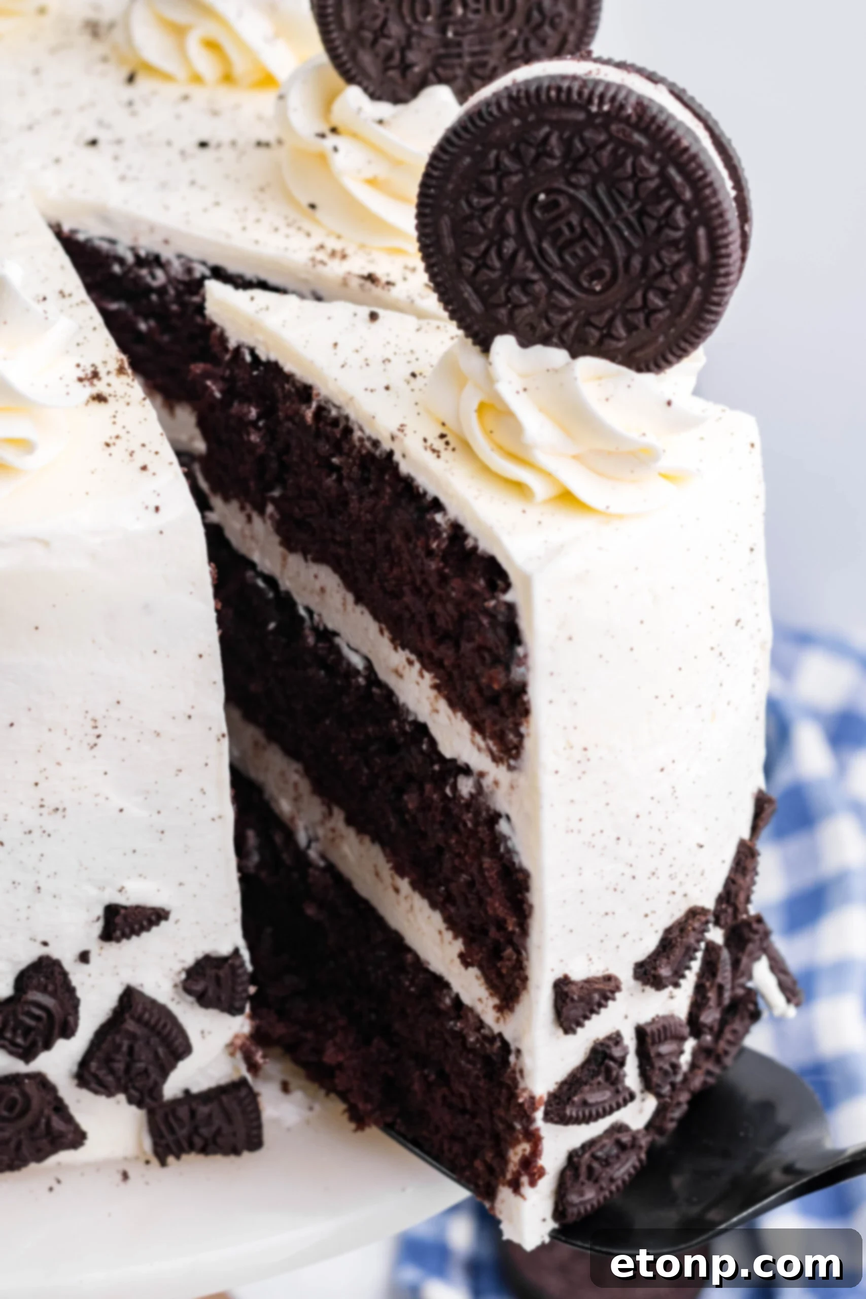 Close up view of a slice being removed from Double Stuffed Oreo Cake.
