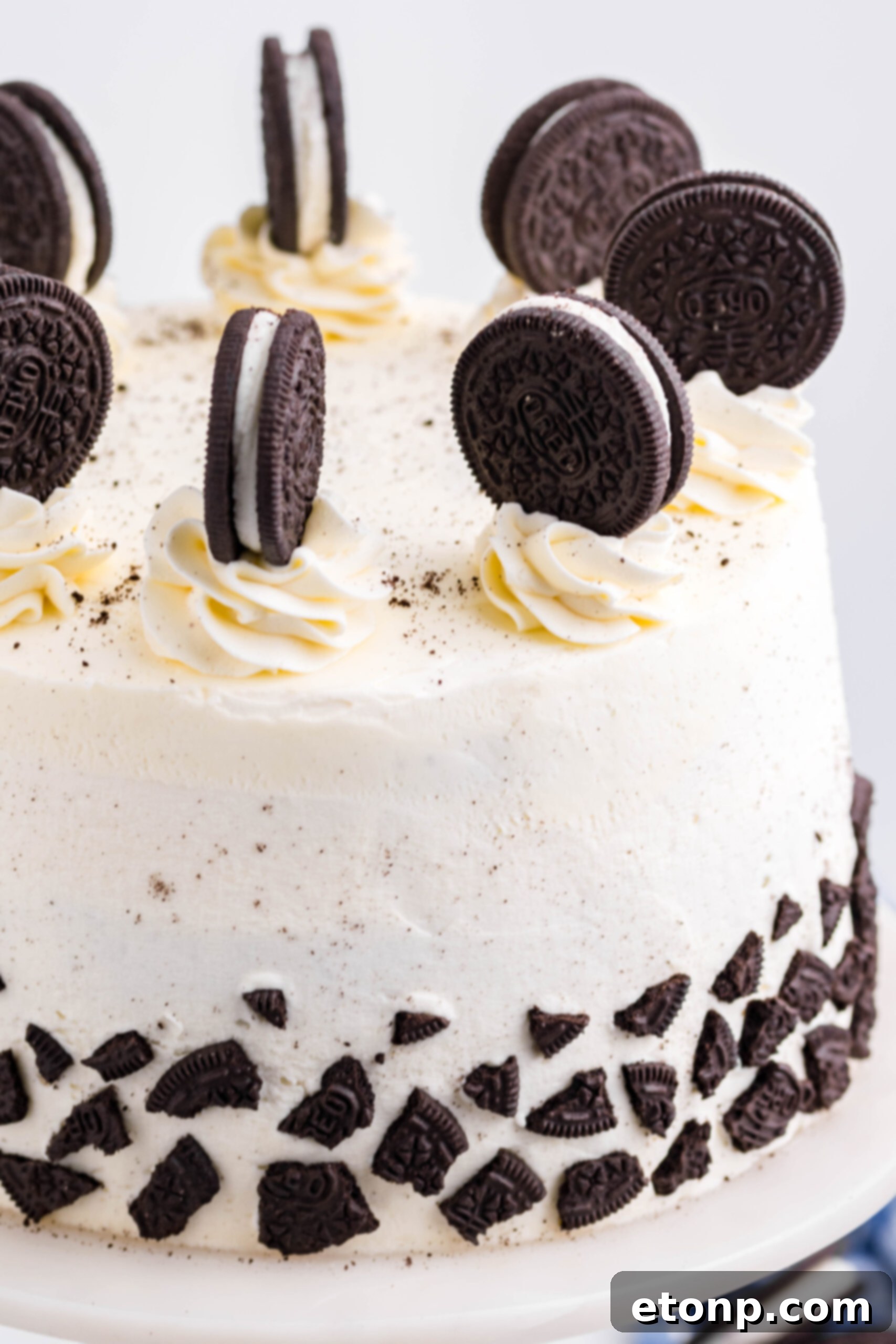 Close up view of Double Stuffed Oreo Cake on a white and wood cake stand.