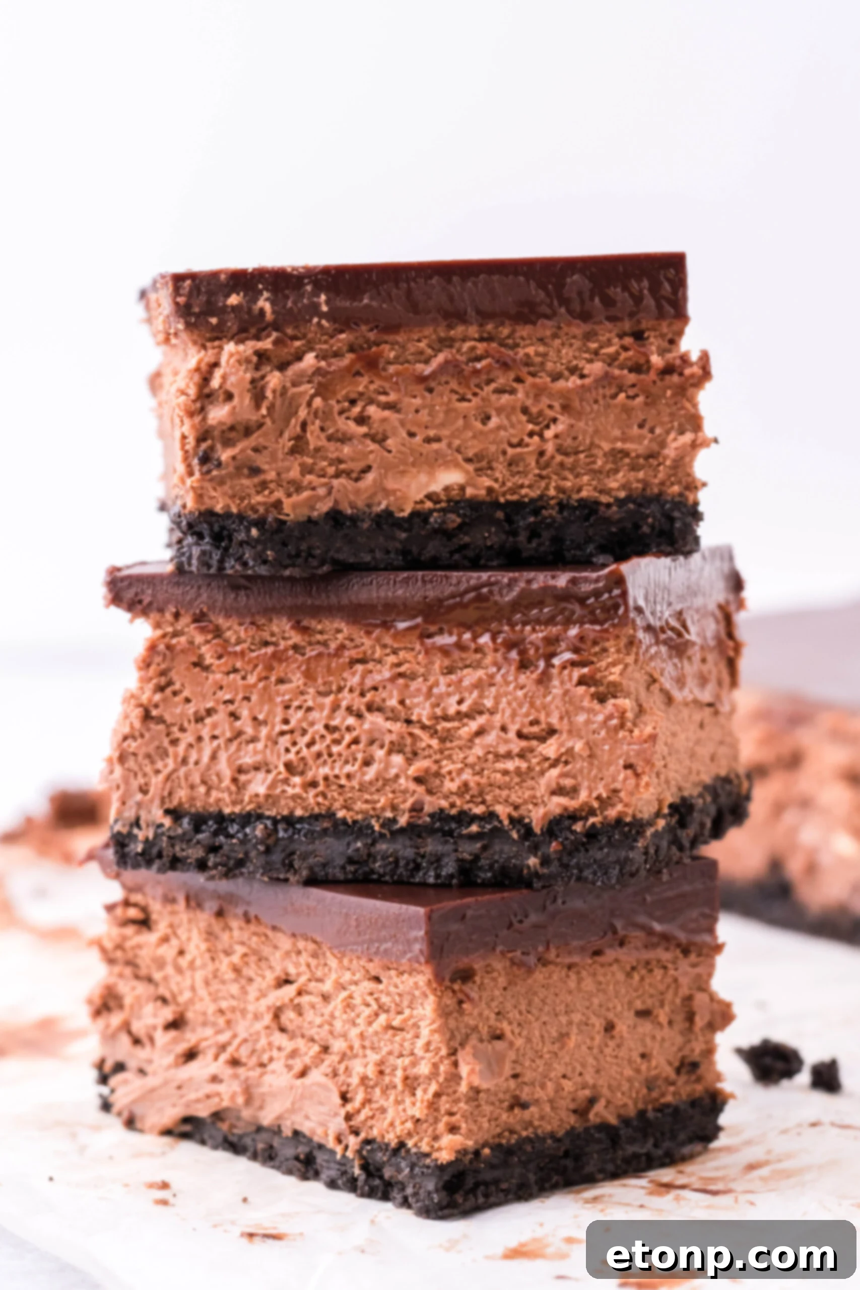 Three bars of chocolate cheesecake stacked on top of each other. 