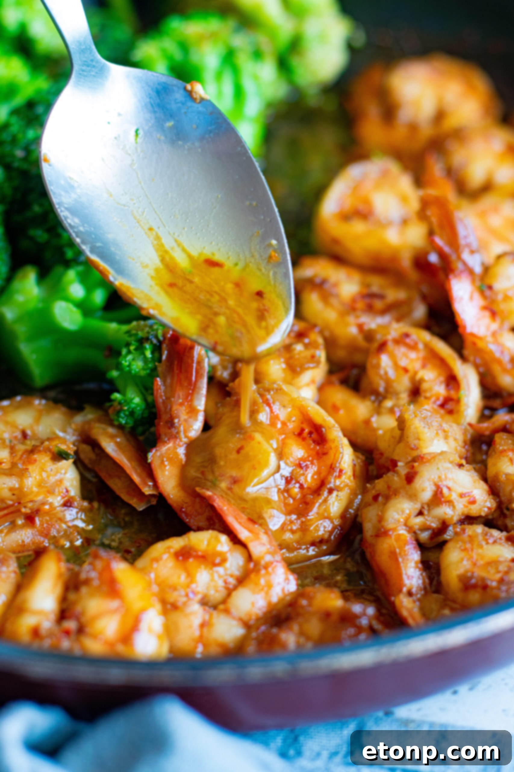 Garlic Shrimp and Broccoli Skillet 5 A silver spoon spooning sauce over the shrimp.