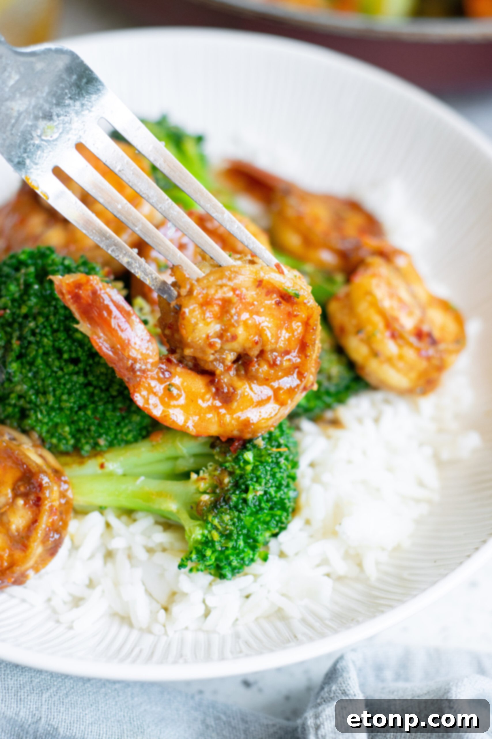 Garlic Shrimp and Broccoli Skillet 10 Up close view of a fork removing a shrimp from the plate.