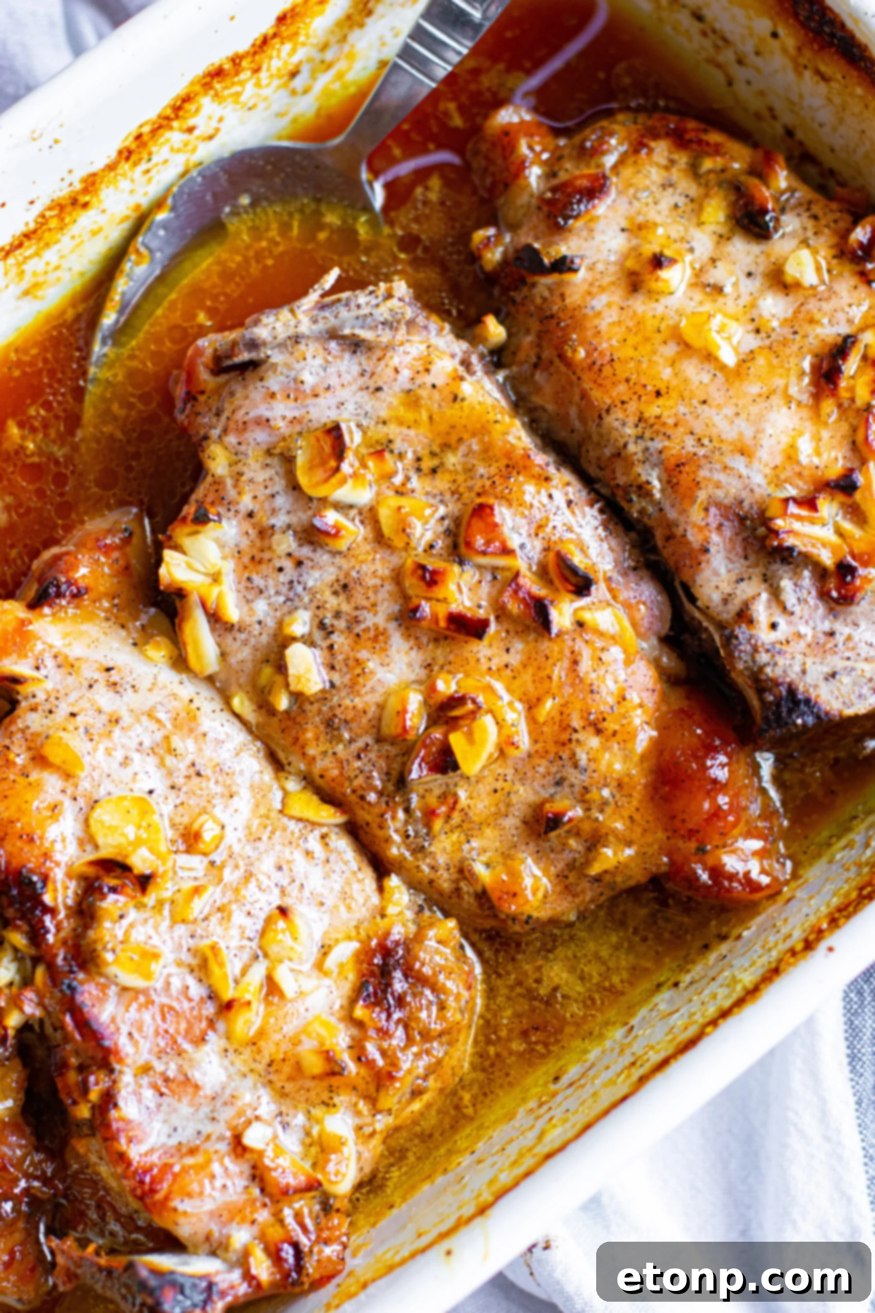 Close up view of Honey Garlic Pork Chops in a white baking dish, ready to be served.