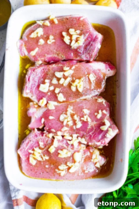 Pouring honey garlic marinade over pork chops in a baking dish.