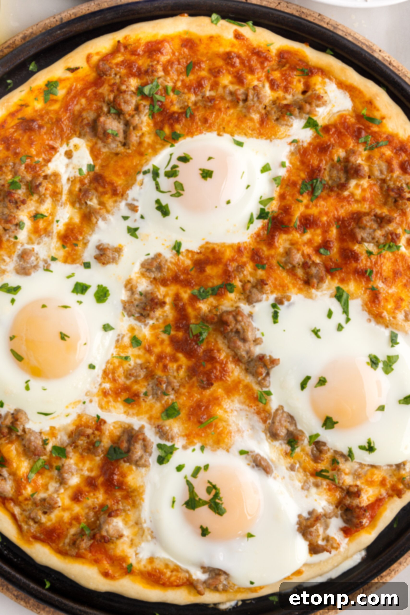 Overhead view of Breakfast Pizza on a black pizza dish.