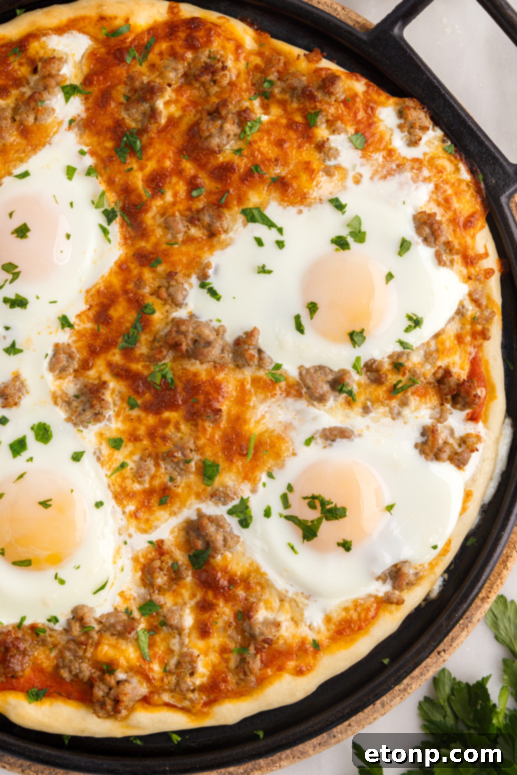 Overhead view of Breakfast Pizza on a black pizza dish.