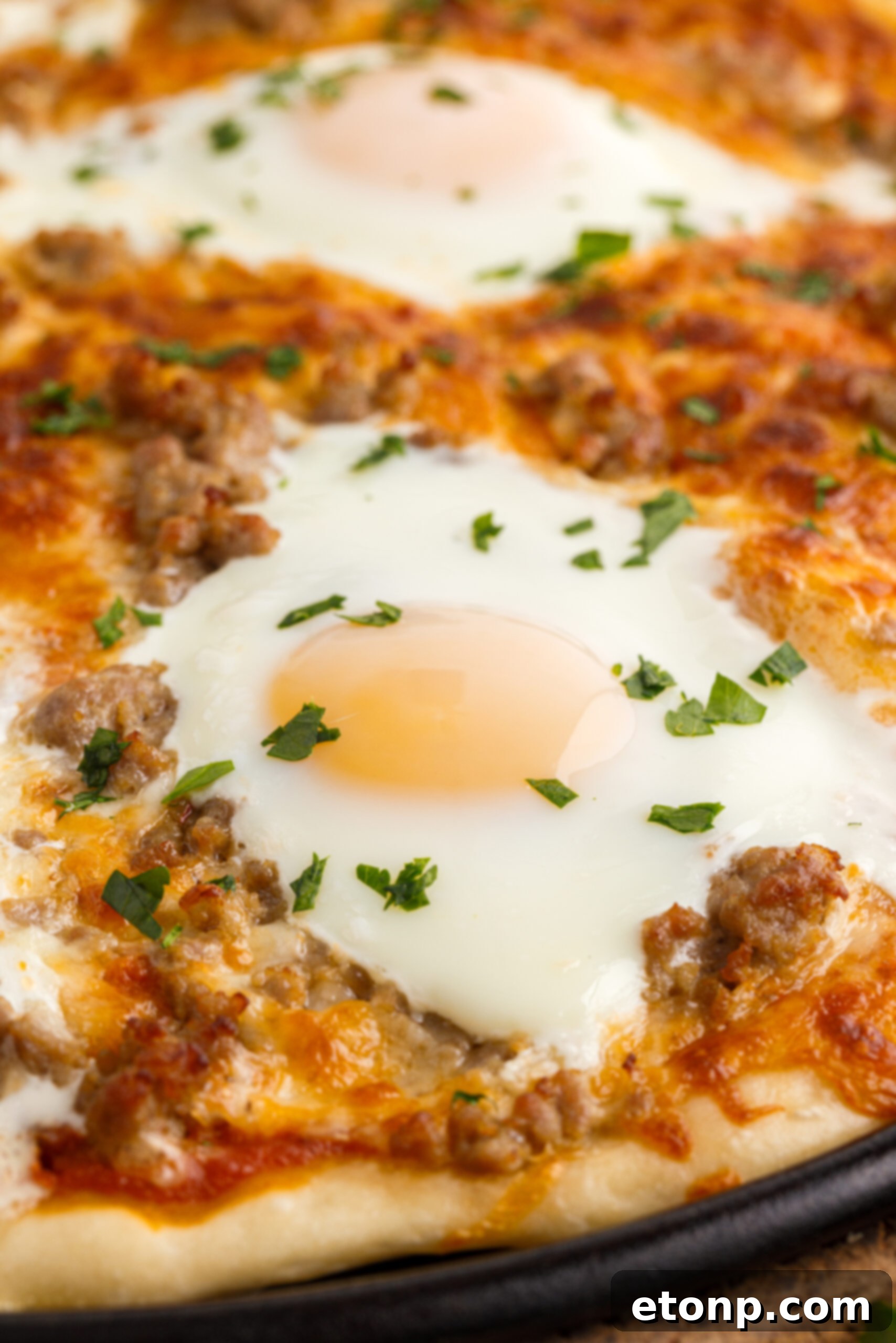 Close up view of Breakfast Pizza on a black pizza dish.