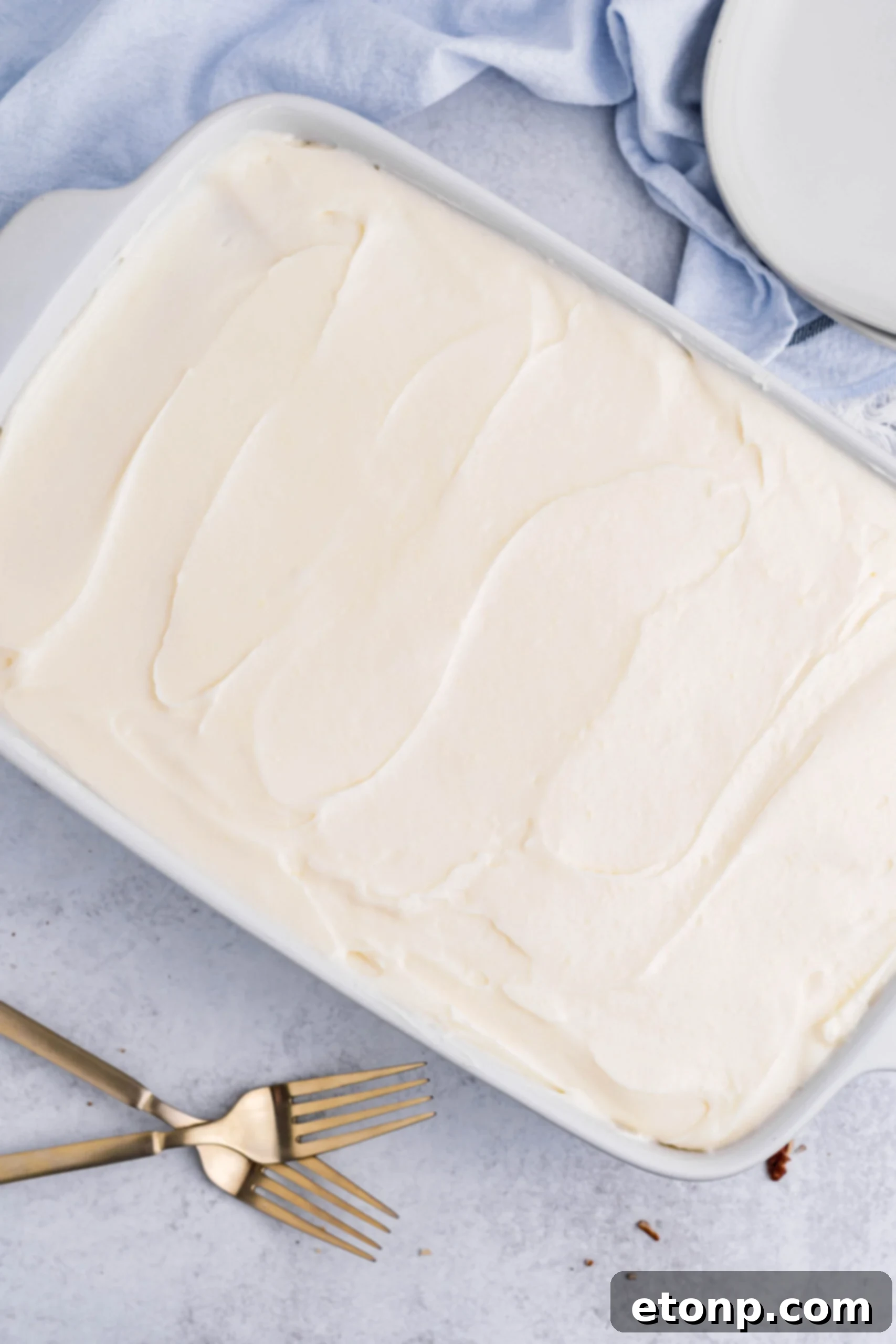 Overhead view of Banana Sheet Cake in a white baking dish.