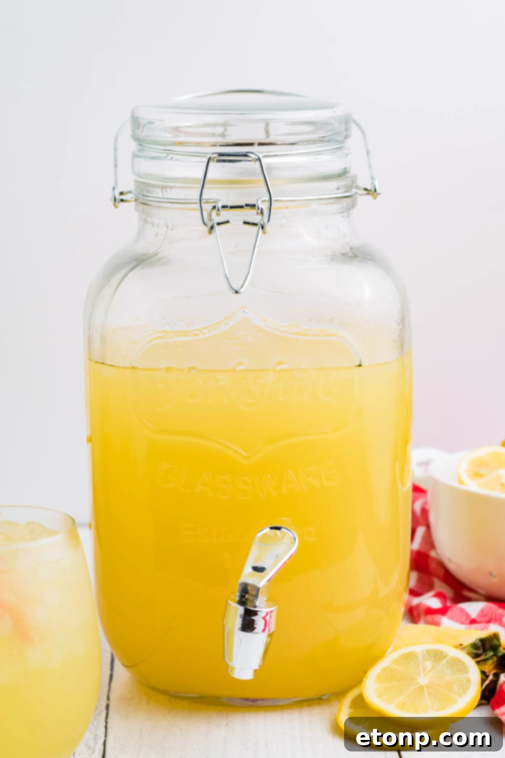 Front view of Pineapple Vodka Lemonade in a drink dispenser, ready for a party.