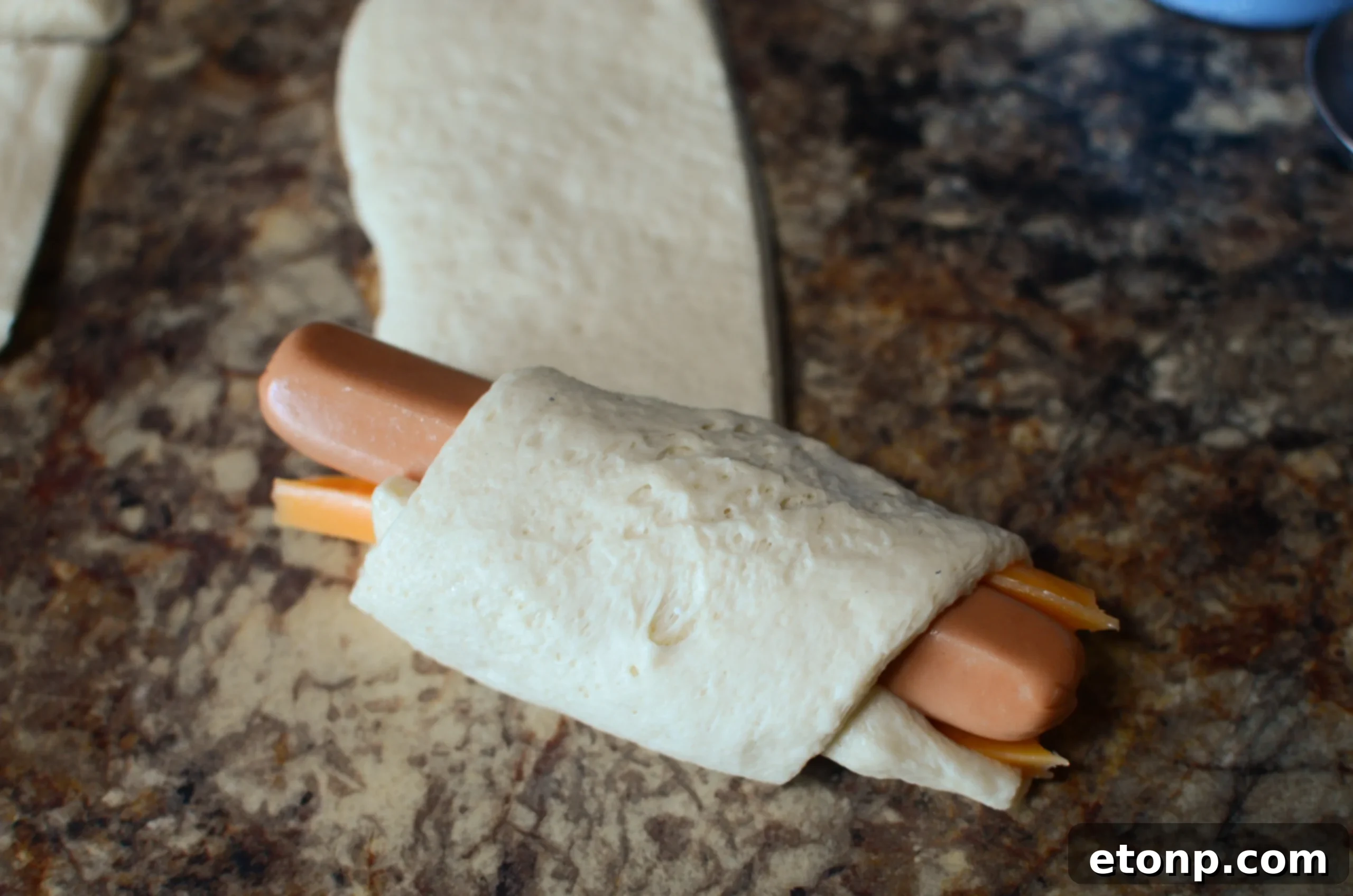 Wrapped hot dogs in baking dish with chili