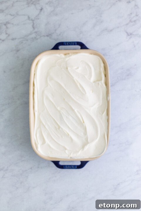 The final layer of whipped topping smoothed over the top of the banana icebox cake, ready for chilling.