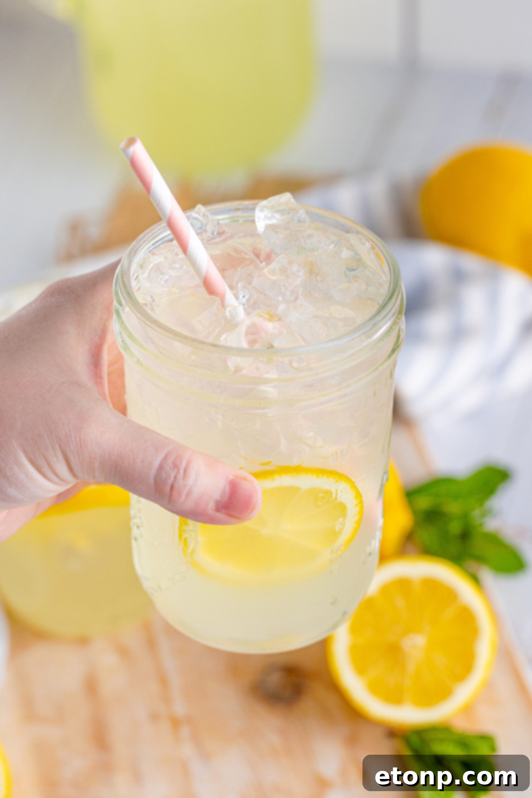 A vibrant pitcher of homemade lemonade, ready to be served, alongside fresh lemon slices.