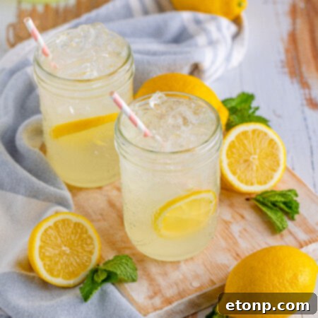 Homemade Lemonade in a mason jar, garnished with a lemon slice, highlighting its refreshing appeal.