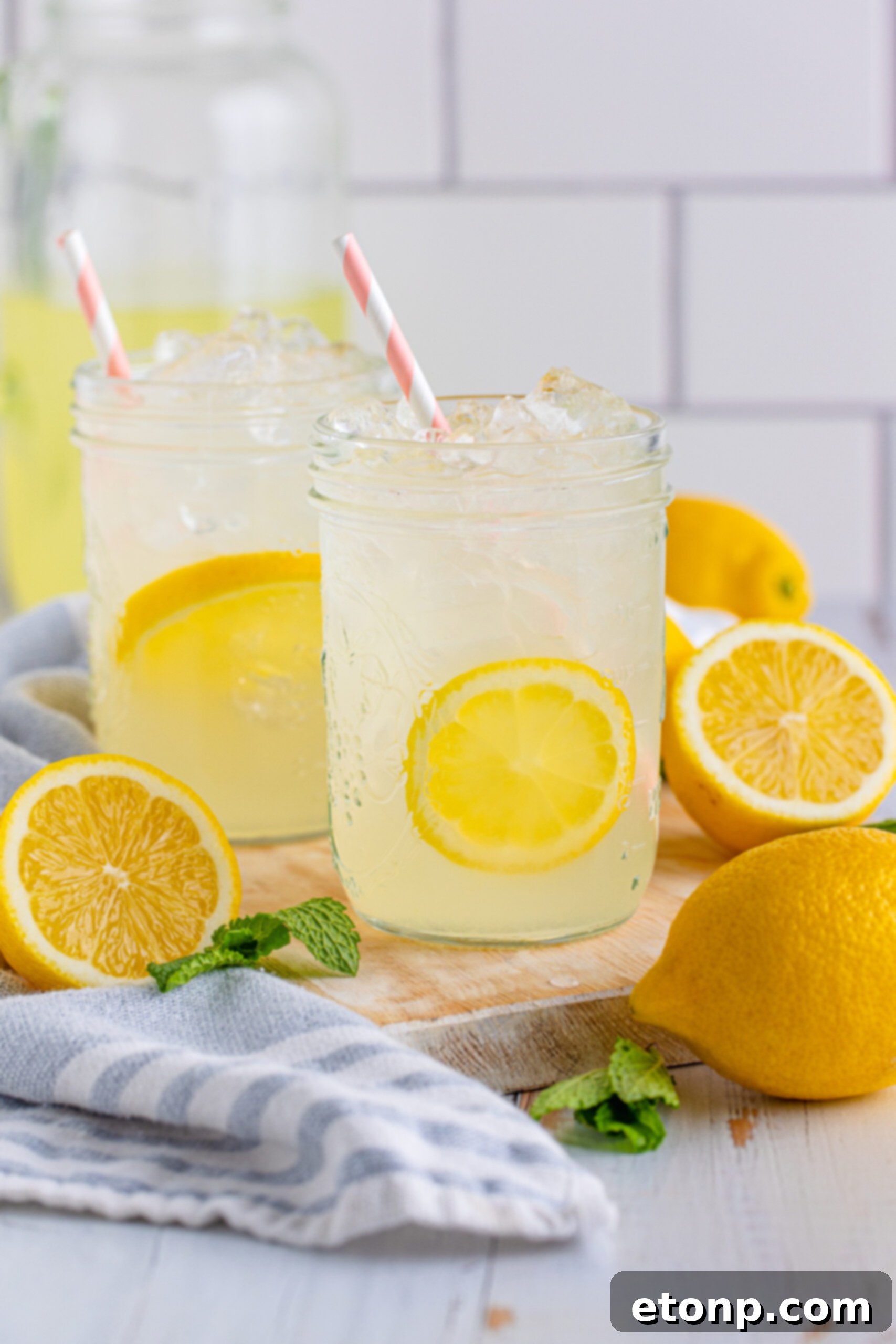 A close-up of a single mason jar filled with homemade lemonade, adorned with lemon slices, highlighting its fresh appeal.