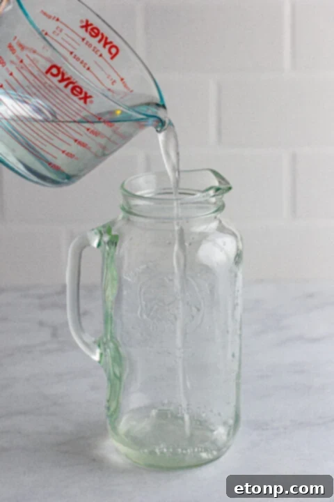 Freshly squeezed lemon juice being poured into a measuring cup.