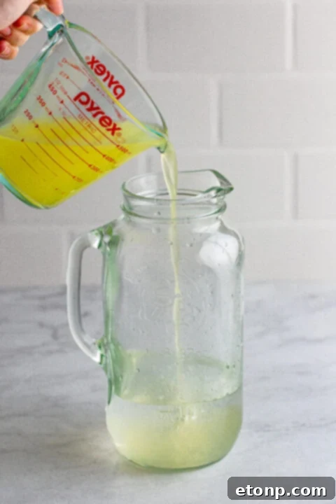 Granulated sugar dissolving in water over a stovetop for simple syrup.