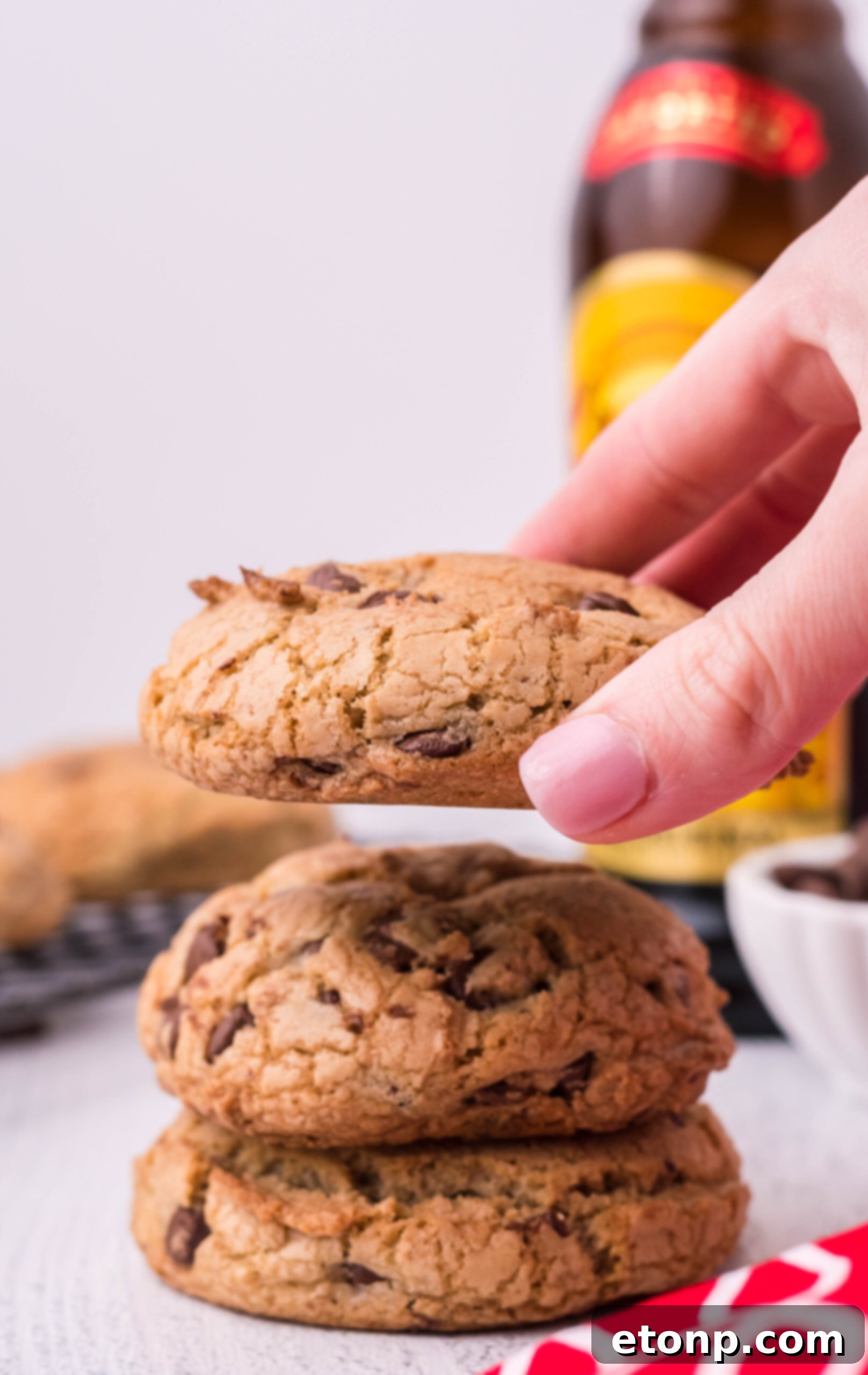 Front view of two Kahlua Cookies stacked and a person's hand holding a single cookie.