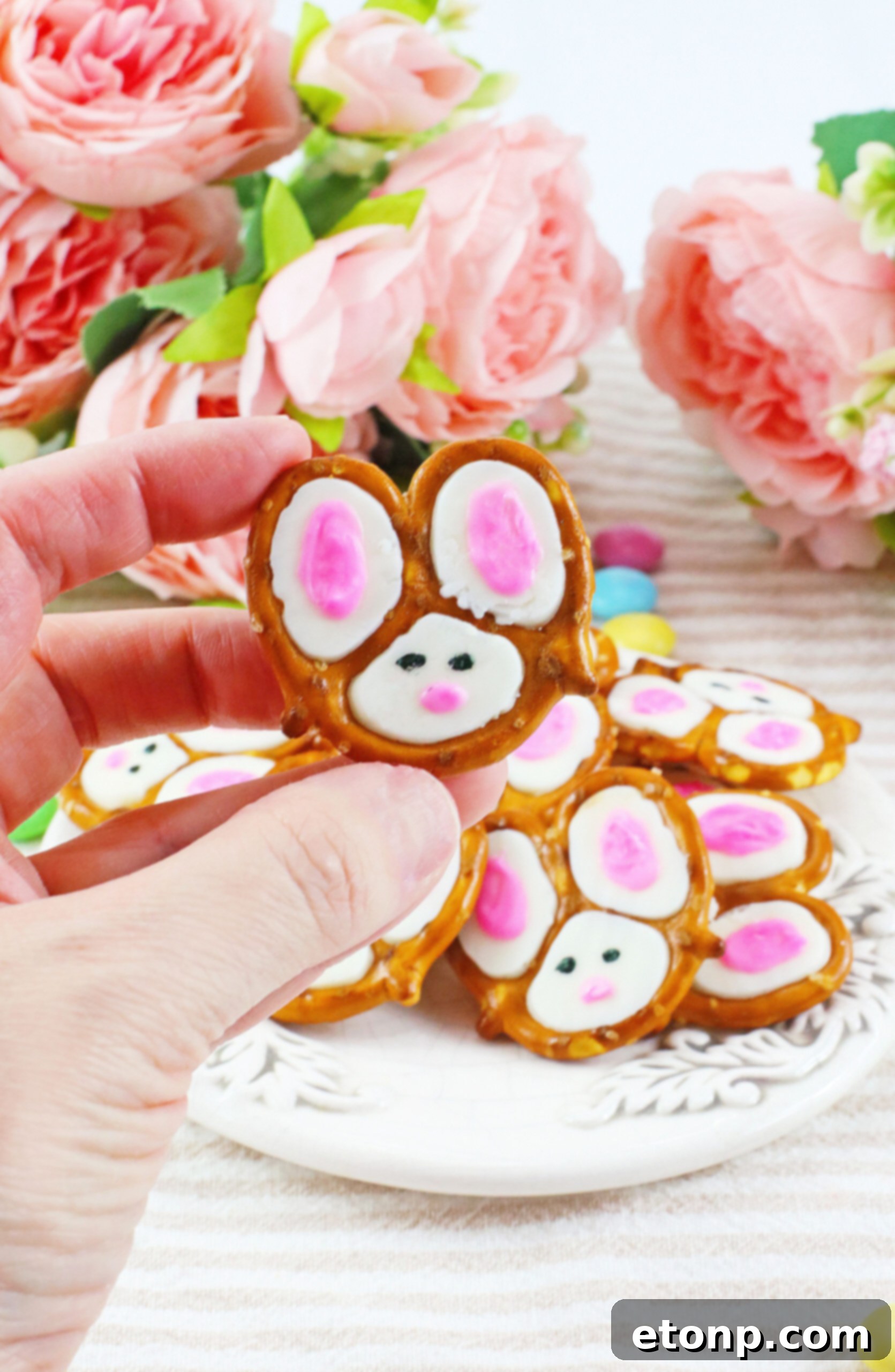 Front view of a single Bunny Pretzel being held gently, showing its detail.
