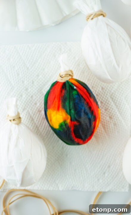 Step-by-step image of applying food coloring to wrapped egg.