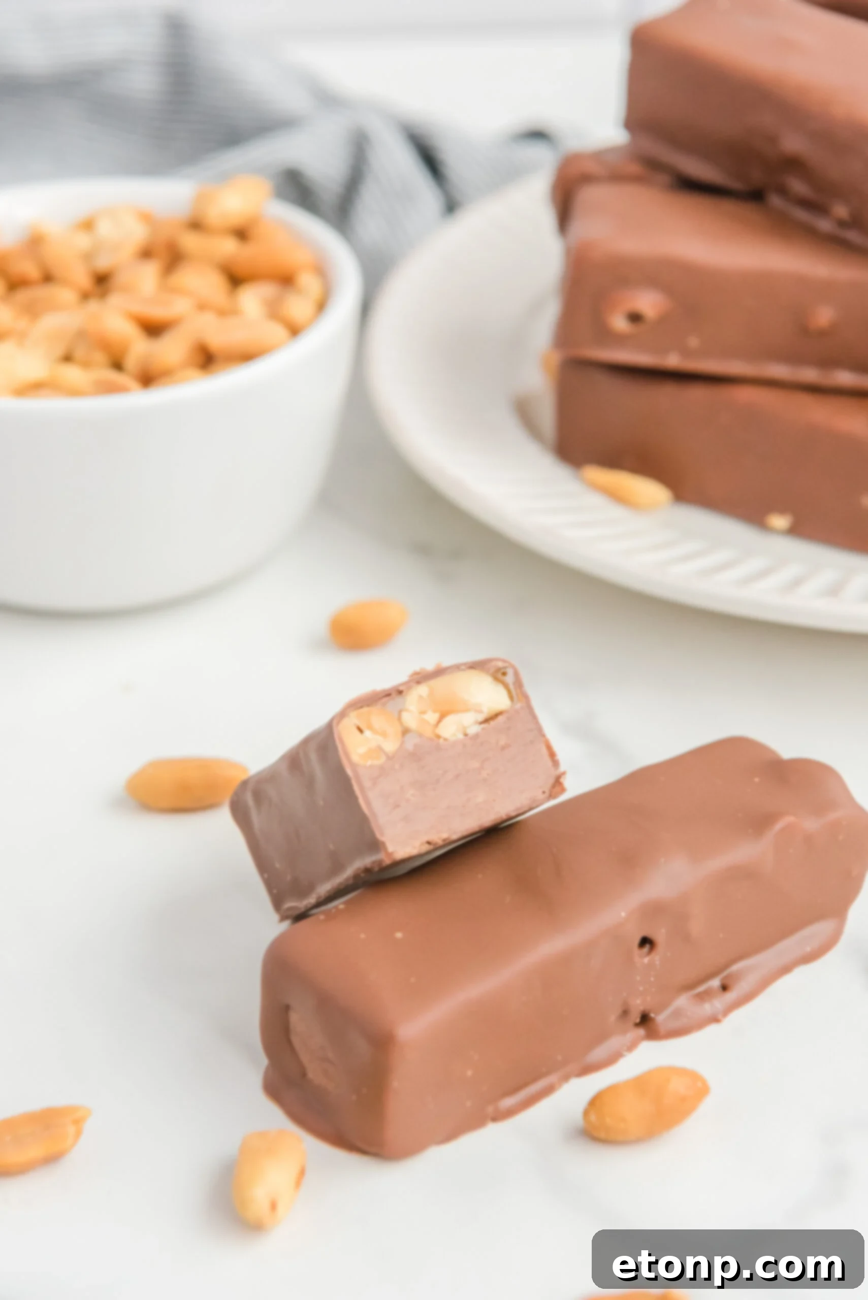 Front view of half of a Homemade Snickers Bars stacked onto a full bar.
