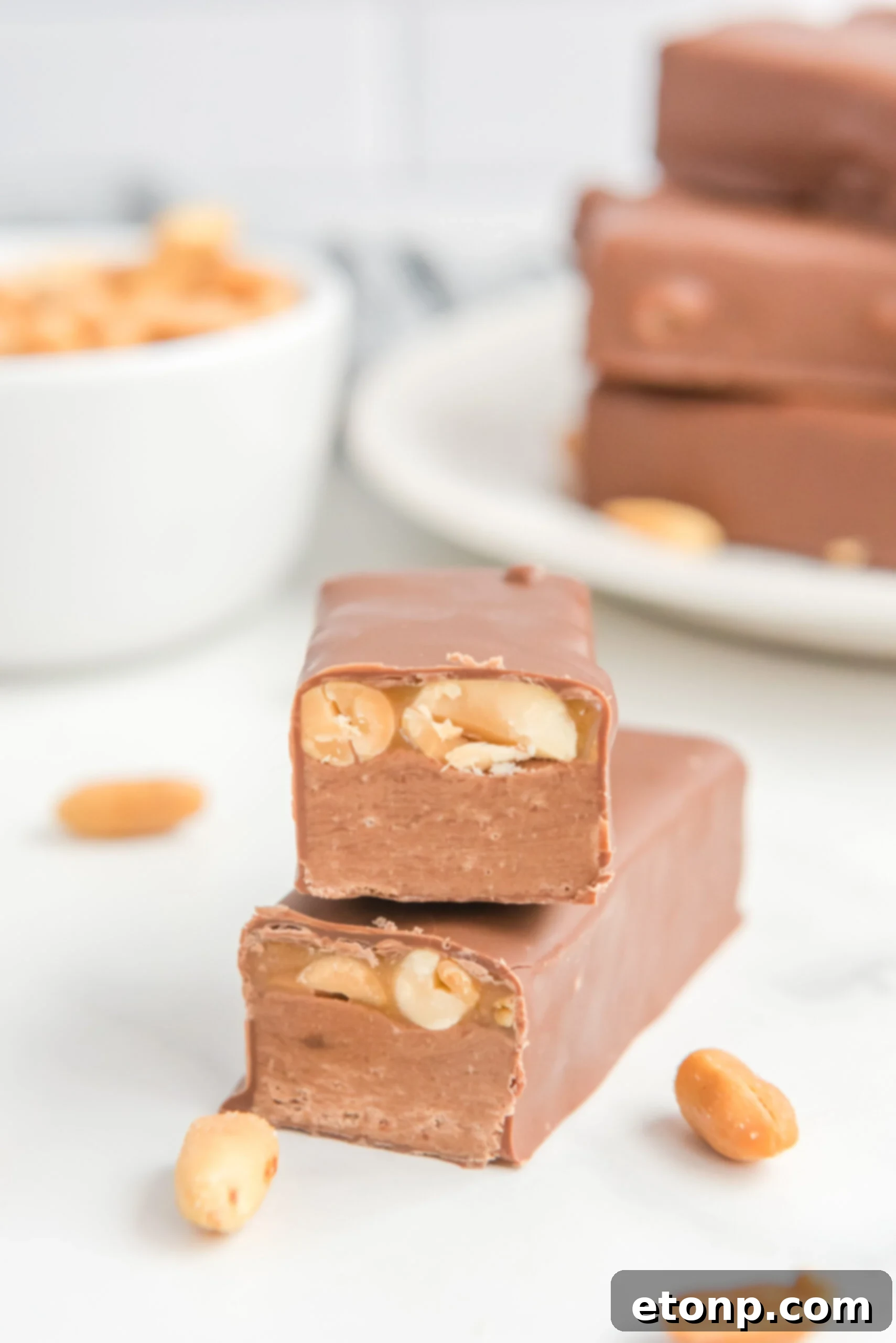 Front view of two halves of Homemade Snickers Bars stacked.