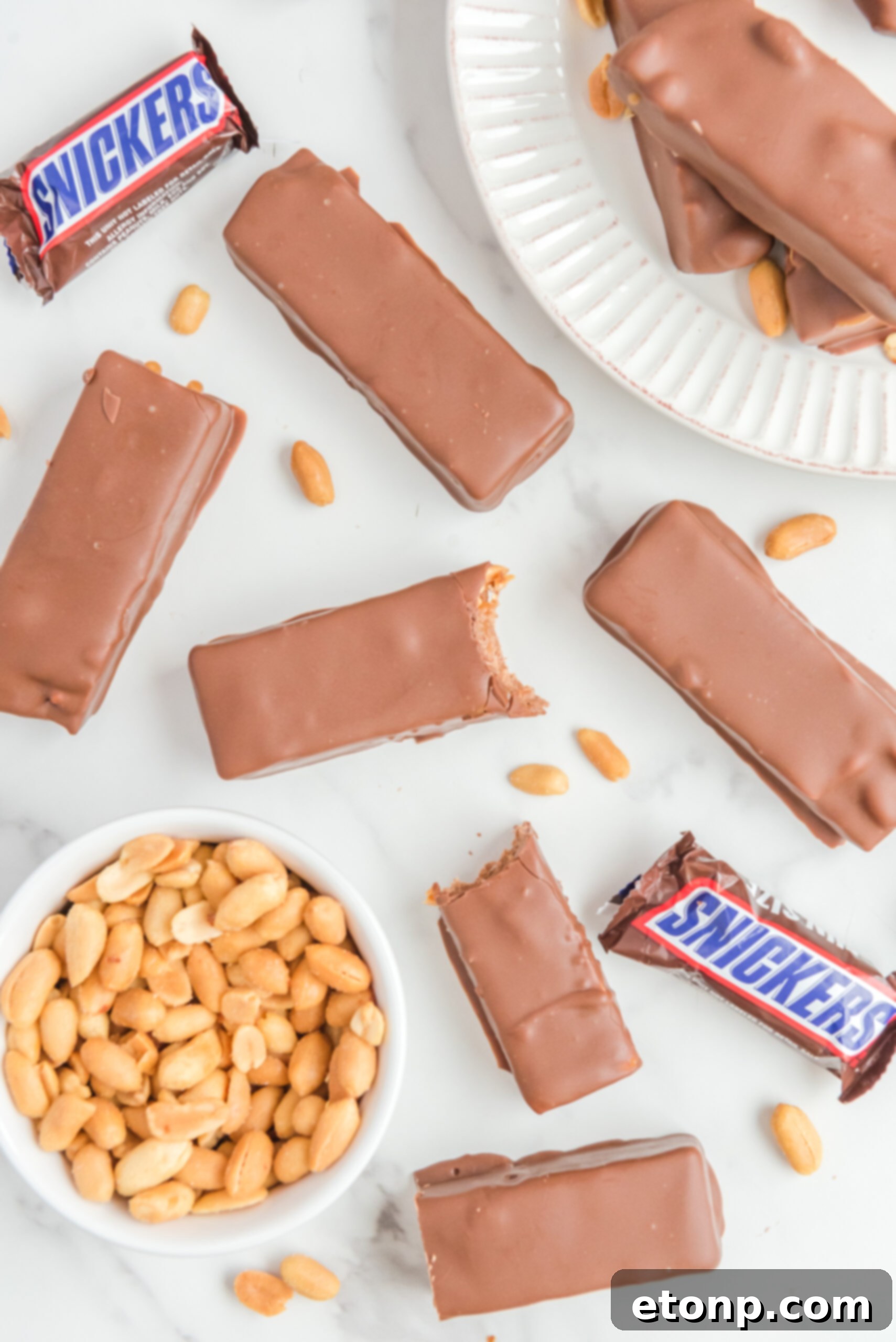 Overhead view of Homemade Snickers Bars with bites removed from two bars.