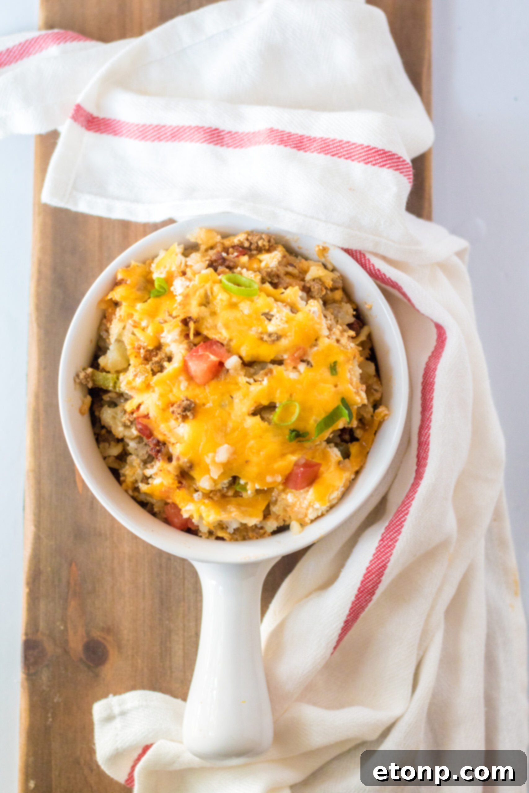 Overhead view of a serving of Slow Cooker John Wayne Casserole in a white bowl.