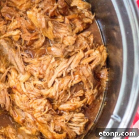 Close up view of Slow Cooker Cola Pulled Pork in a crock pot.