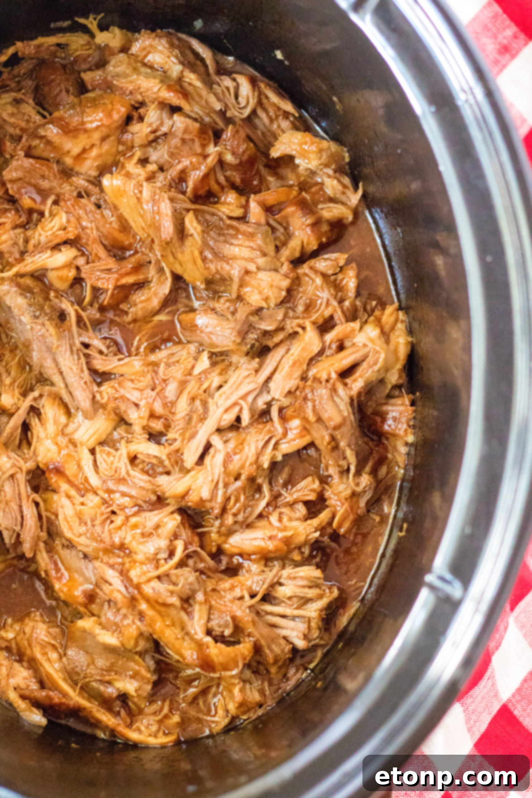 Close up view of Slow Cooker Cola Pulled Pork in a crock pot.