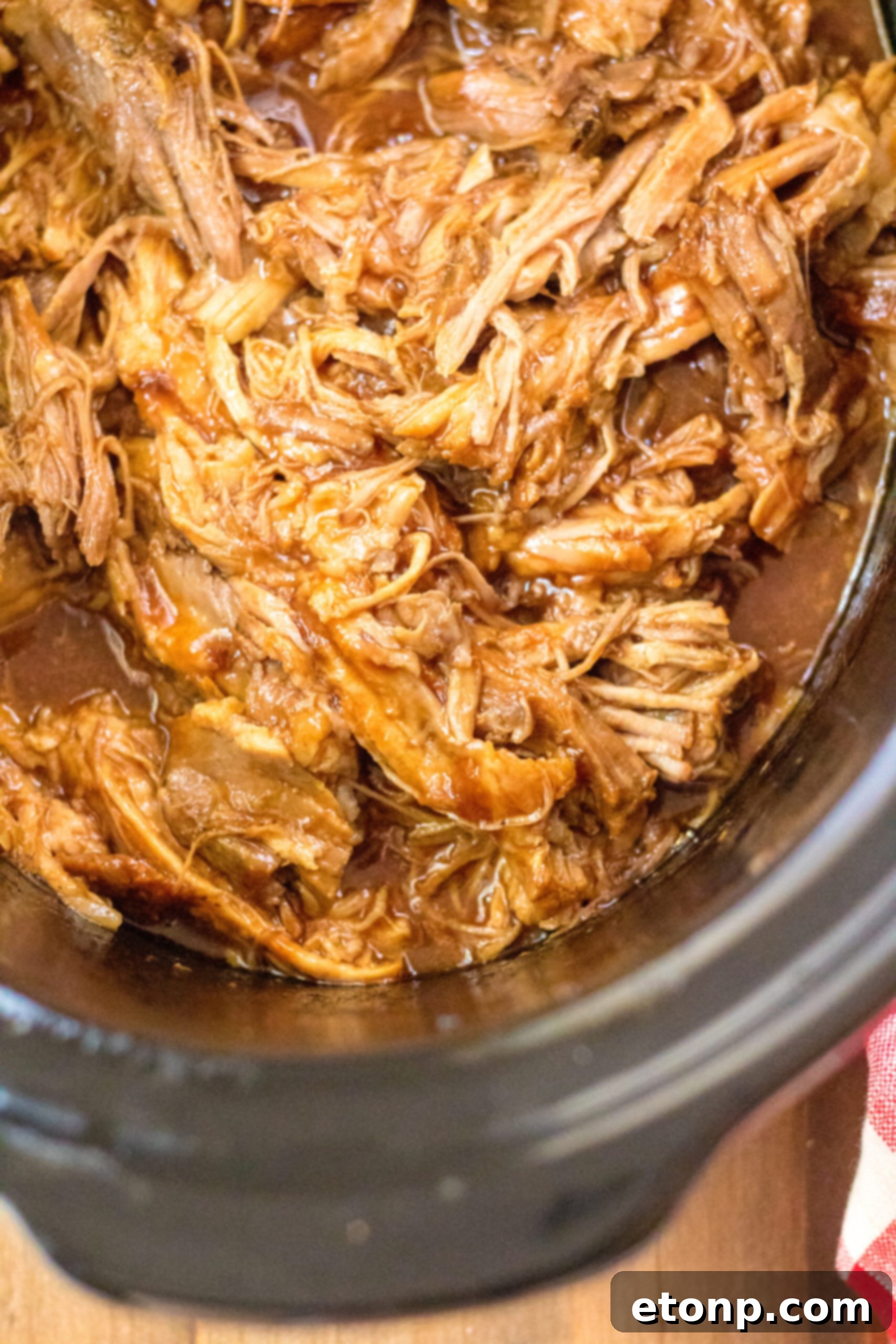 Close up view of Slow Cooker Cola Pulled Pork in a crock pot.