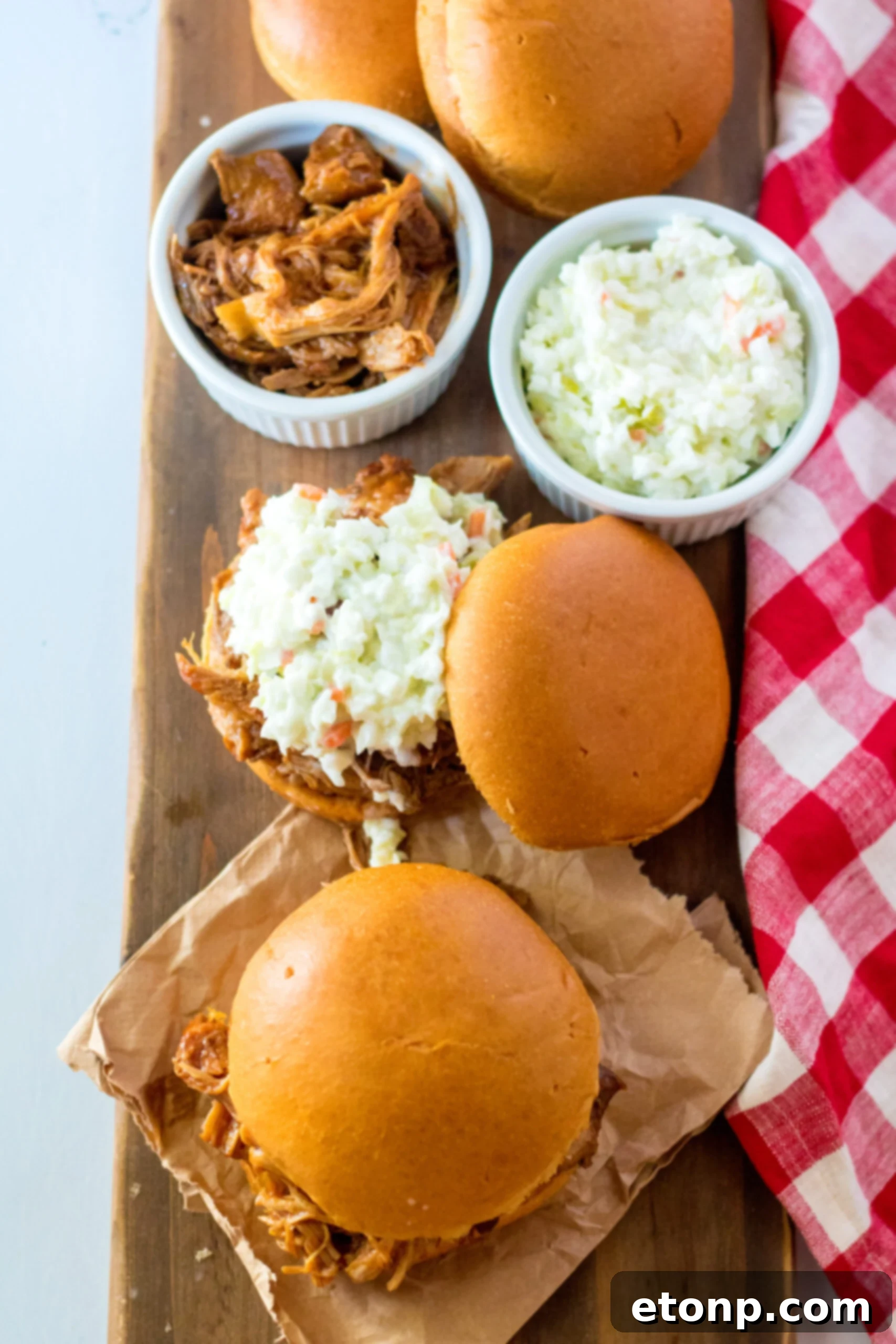 Overhead view of Slow Cooker Cola Pulled Pork on a bun served with coleslaw.