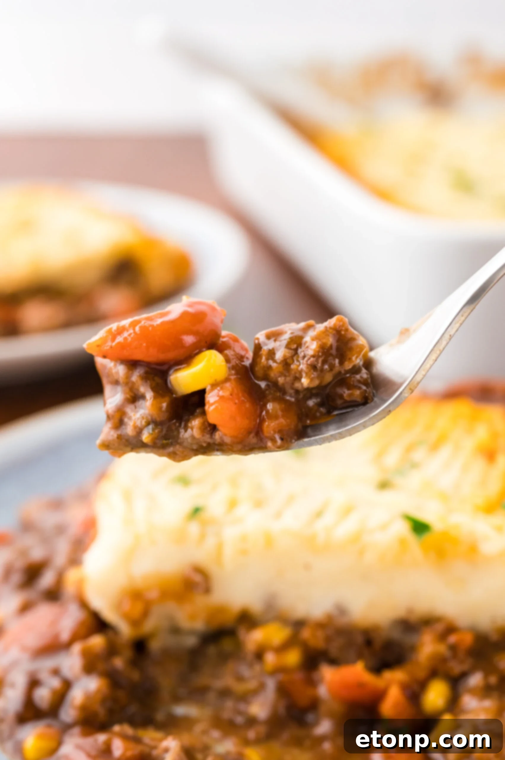 A fork removing a bite of Shepherd's pie. 