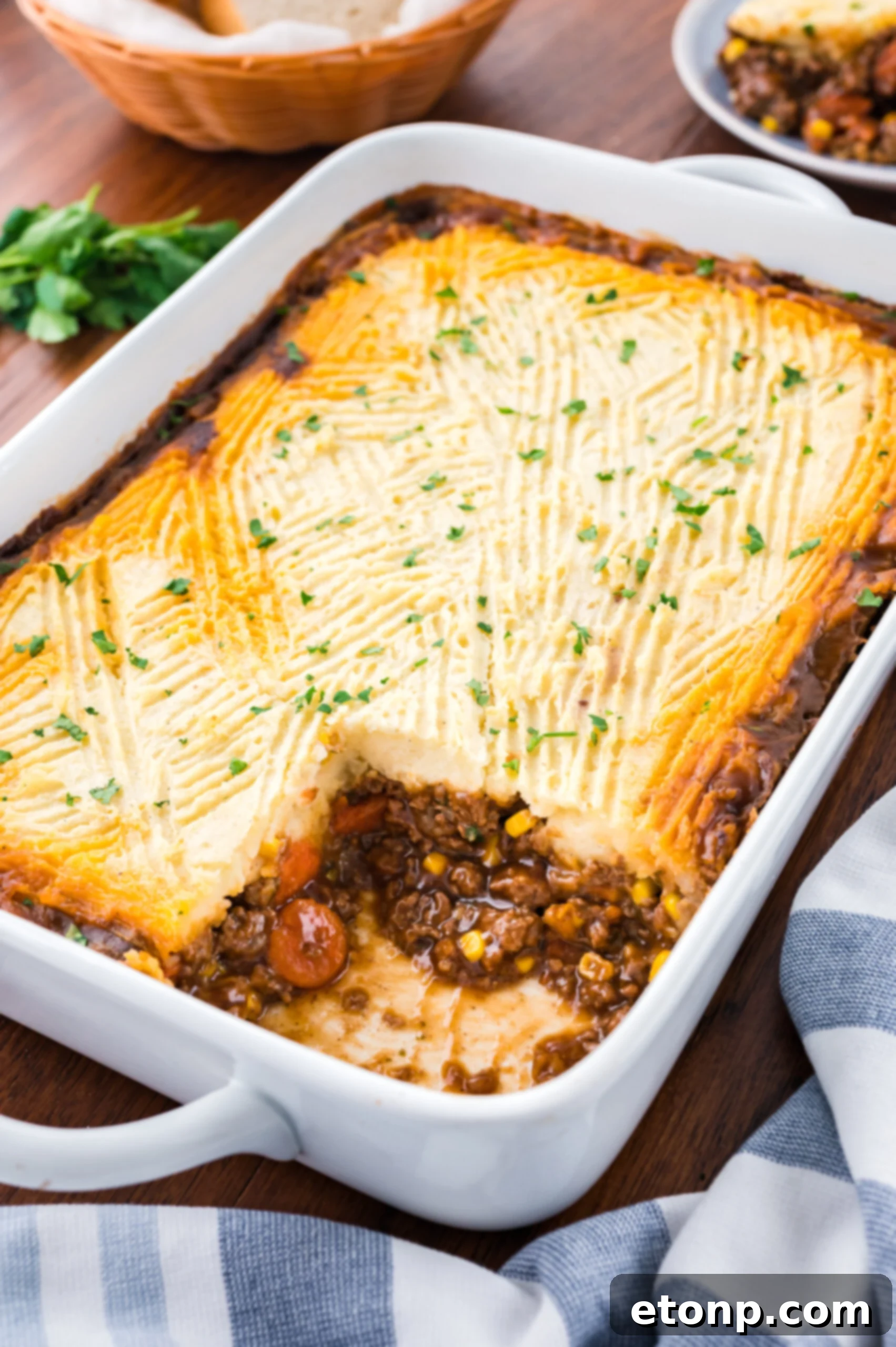 Shepherds pie in a white casserole baking dish with a slice removed